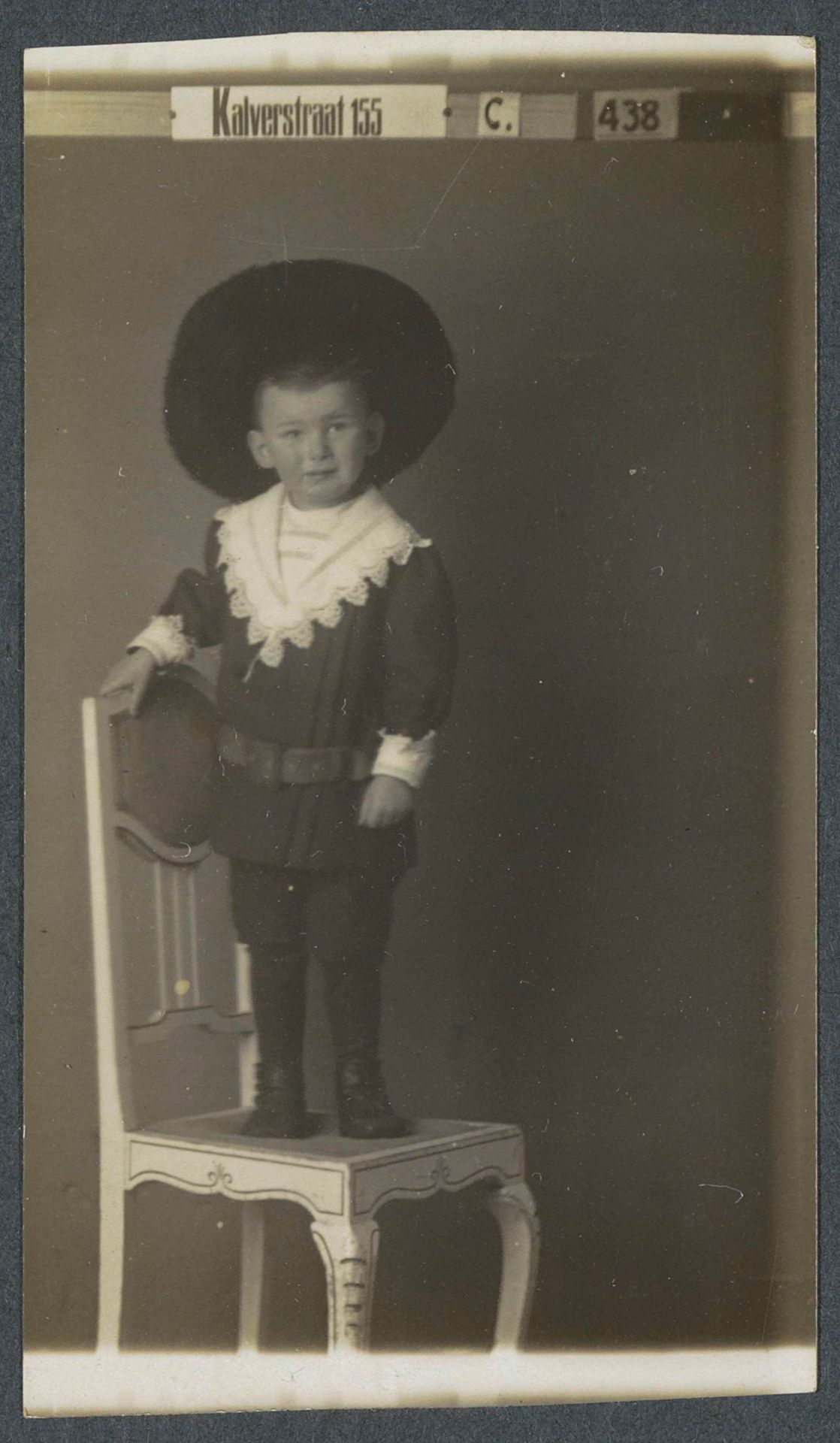 Portret van een kleine jongen met een hoed, staand op een stoel by American Automatic Fotografie
