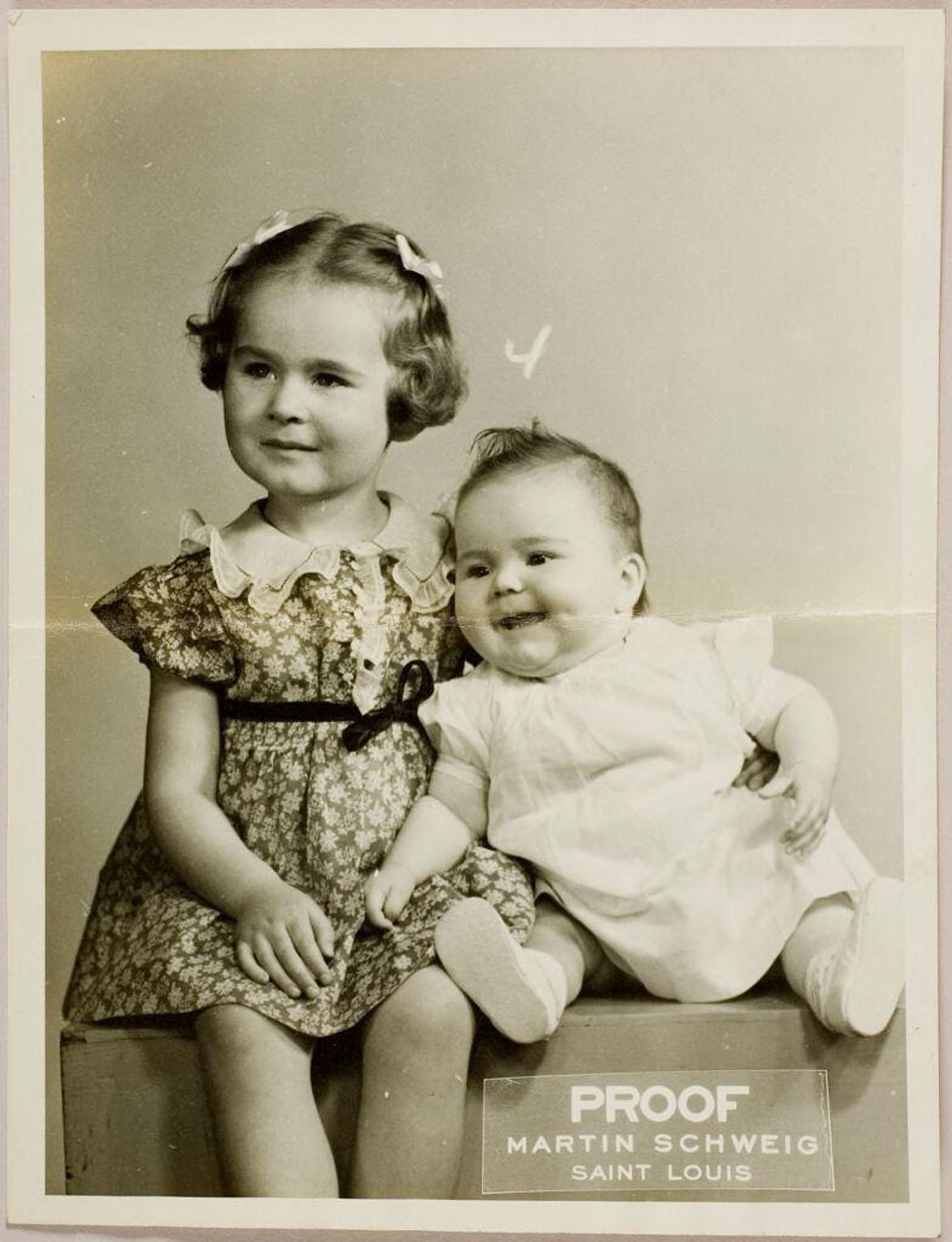 Untitled (double studio portrait of young girl posed sitting with baby sister) by Martin Schweig