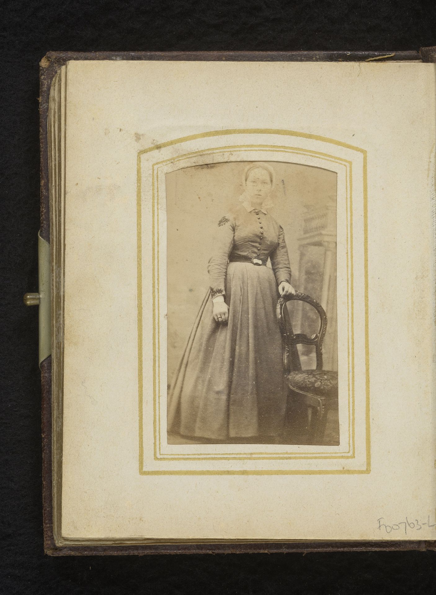 Portret van een vrouw met klederdrachtmuts, staand bij een stoel by Johan Godfried Blankenburg