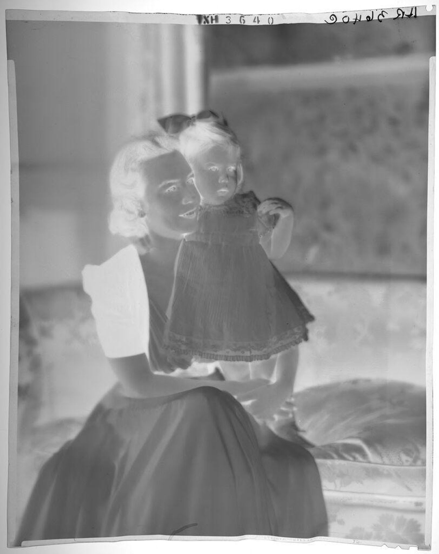 Untitled (woman seated on sofa with little girl in dress standing at side) by Paul Gittings