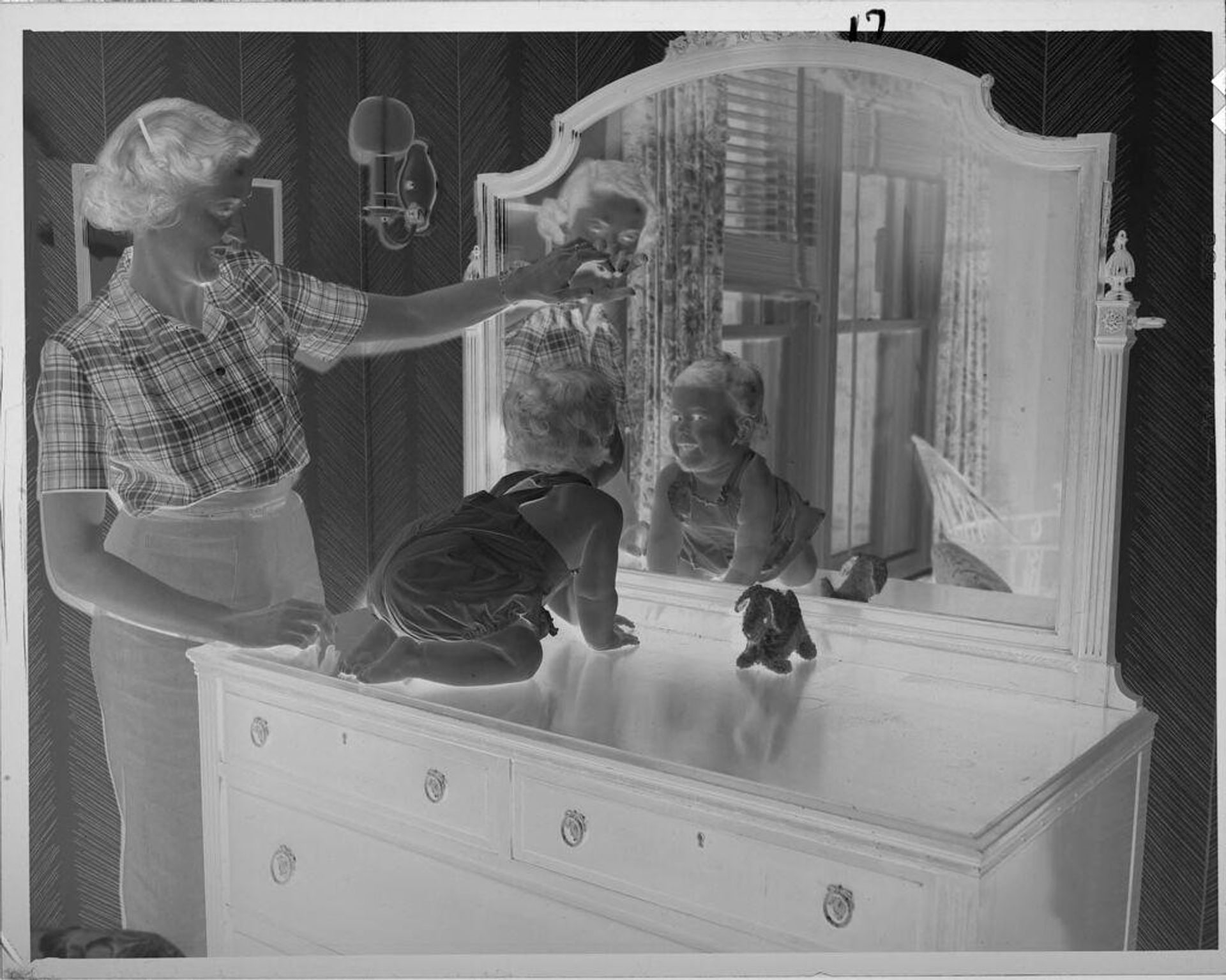 Untitled (baby on bureau looking into mirror) by Lucian and Mary Brown