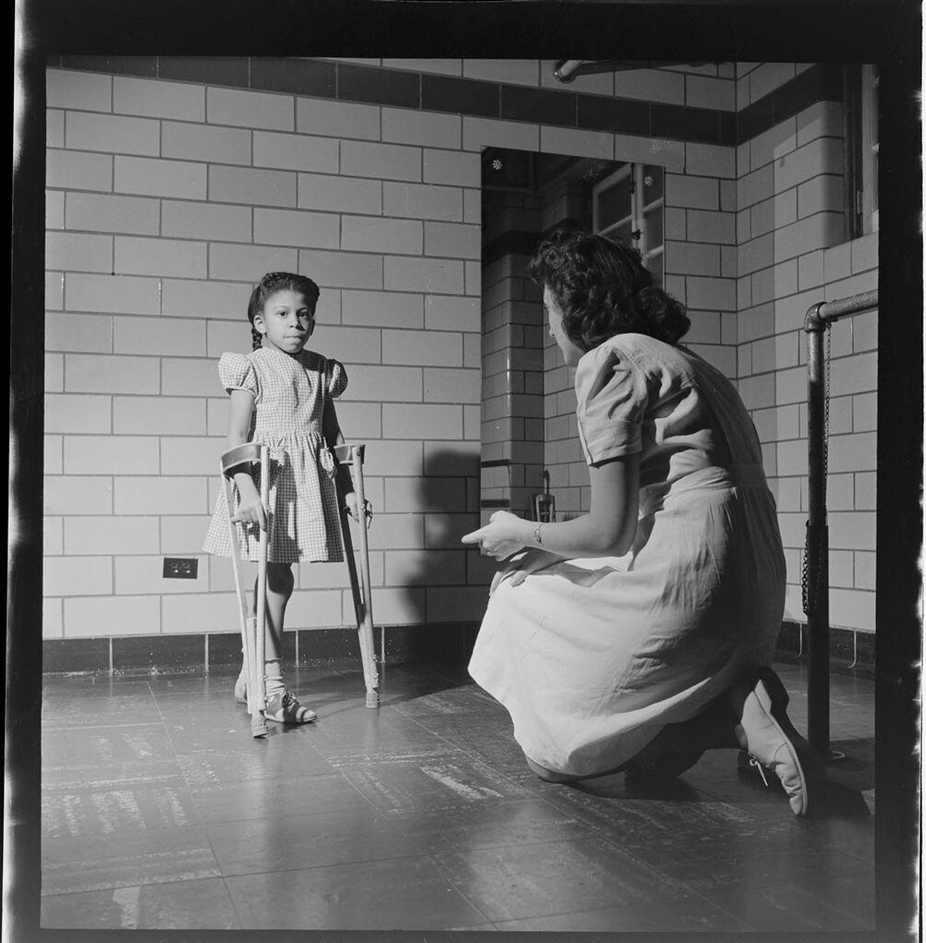 Untitled (child on crutches with nurse) by Jack Gould
