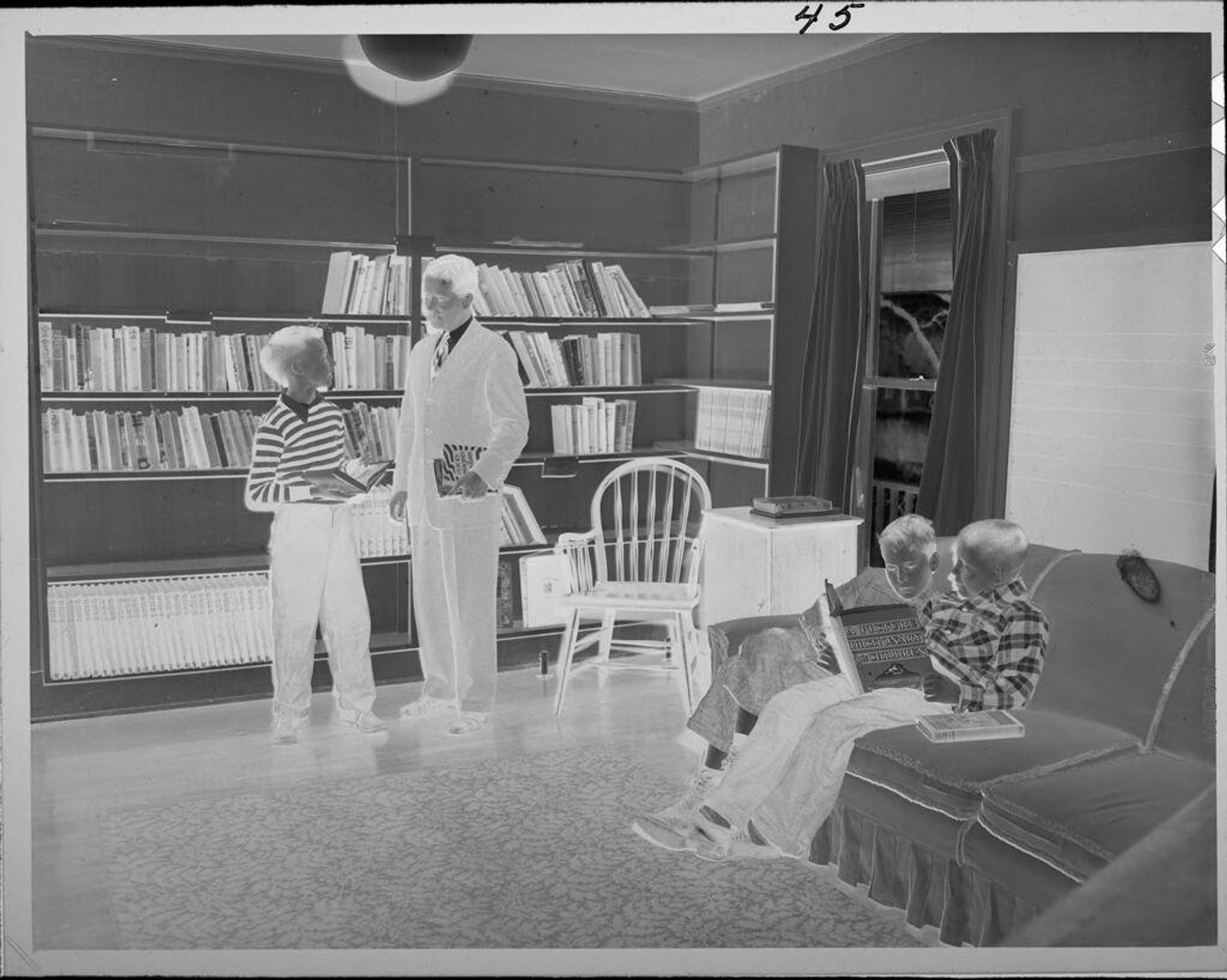 Untitled (man and children in library) by Lucian and Mary Brown
