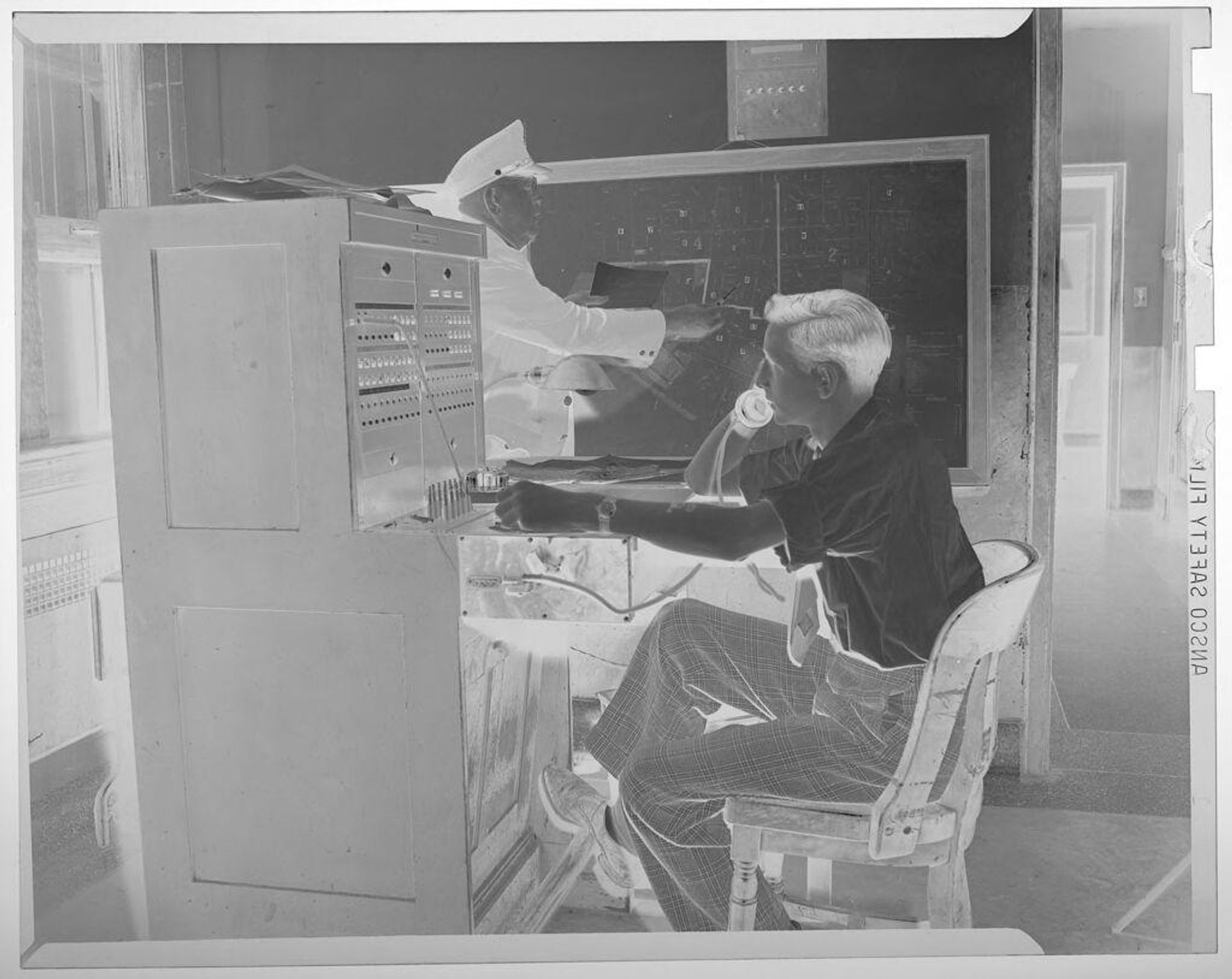 Untitled (man on phone switchboard at police department) by Jack Gould