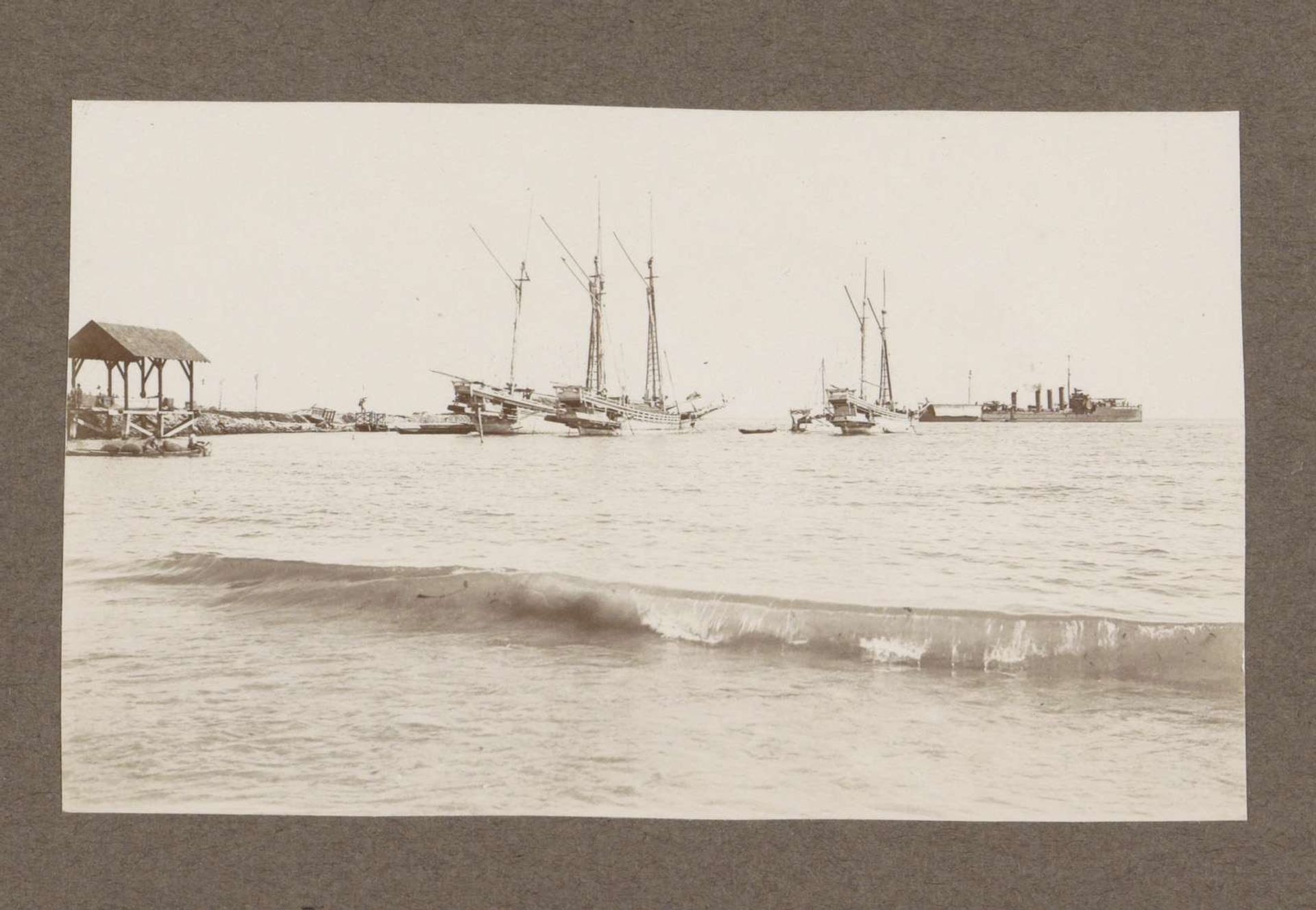 Zeilschepen en (vermoedelijk) een marineschip voor de kust van Nederlands-Indië by Klaas (I) Kleiterp