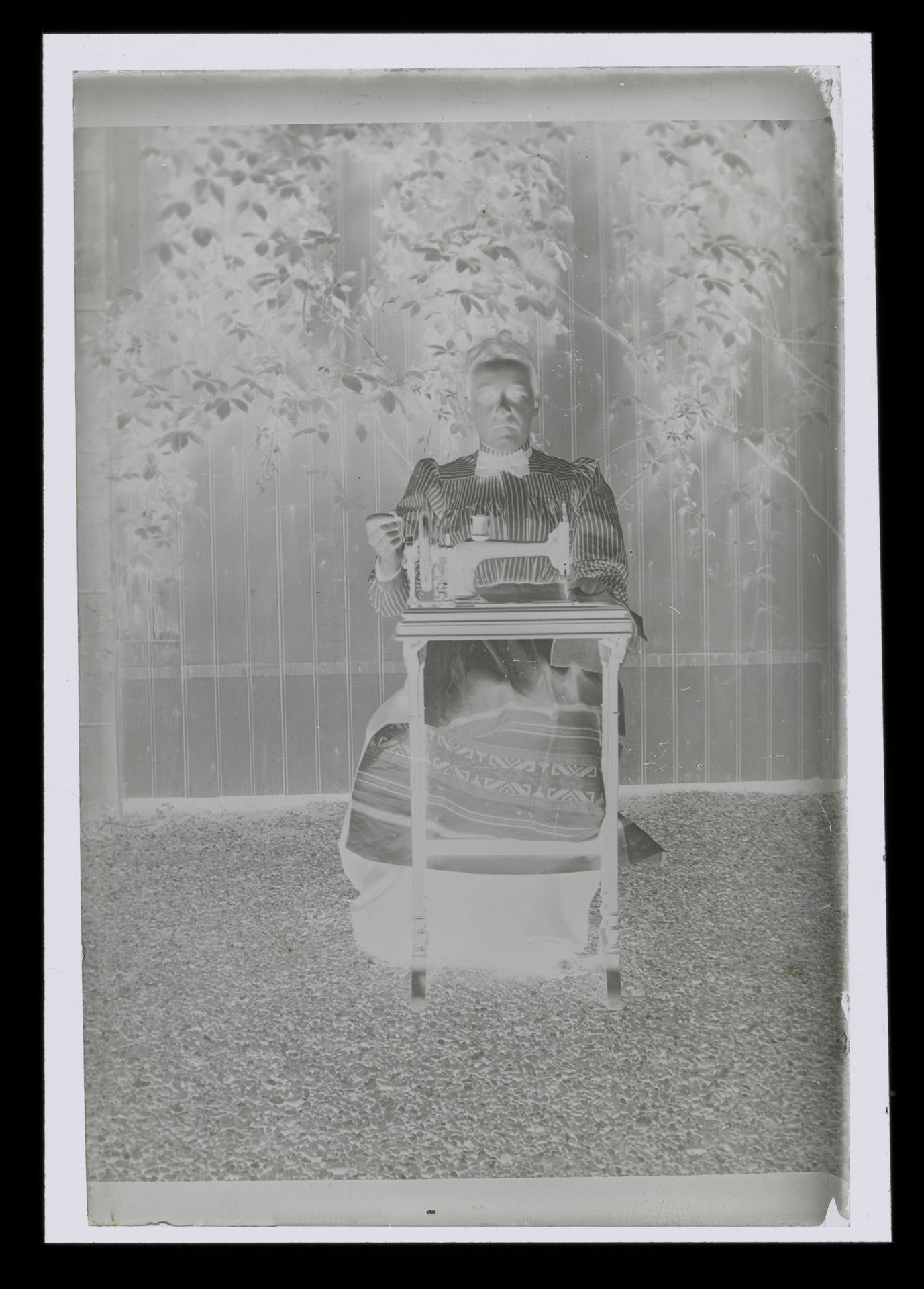 Portret van een onbekende vrouw achter een naaimachine in een tuin by Laurens Lodewijk Kleijn