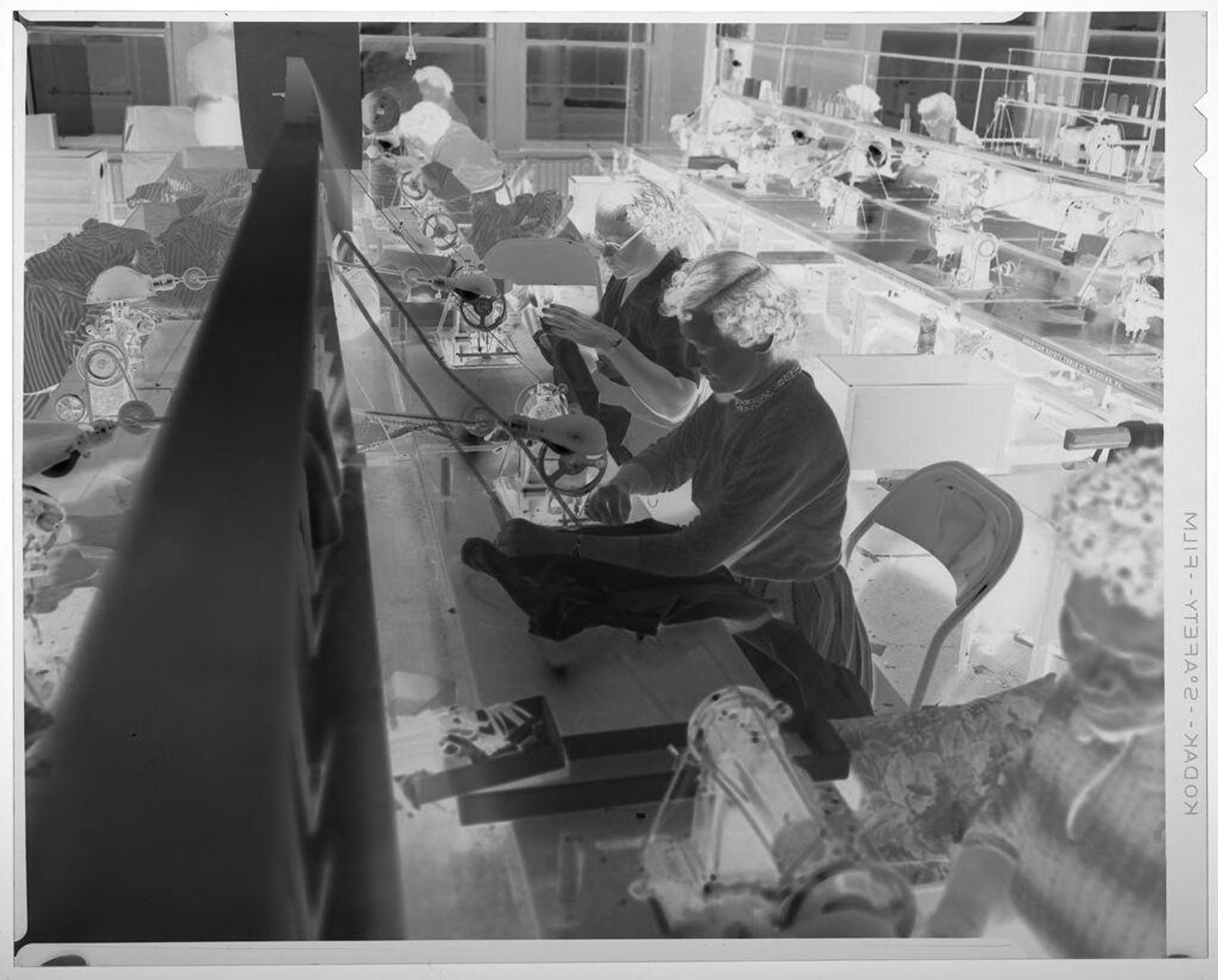 Untitled (line women working on sewing machines in warehouse room) by Martin Schweig