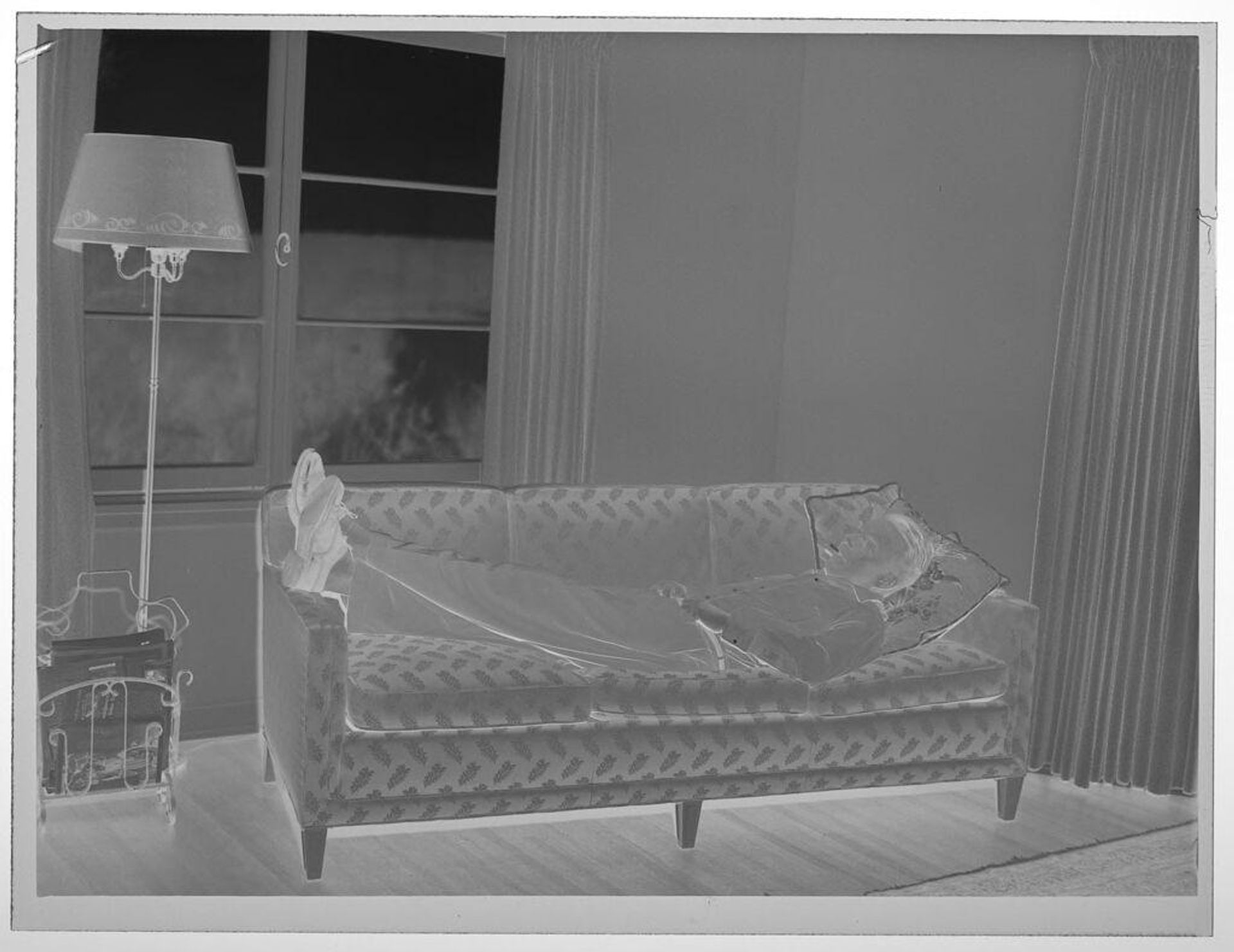 Untitled (man lying on couch, smoking) by Lucian and Mary Brown