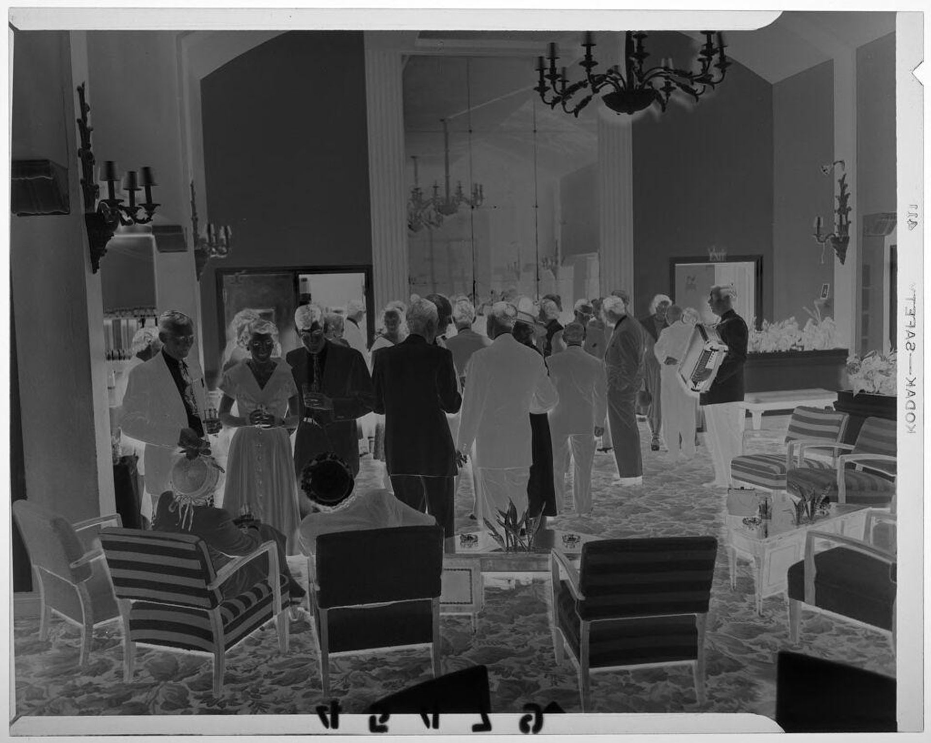 Untitled (guests chatting at party with accordion player standing at edge of gathering) by Martin Schweig