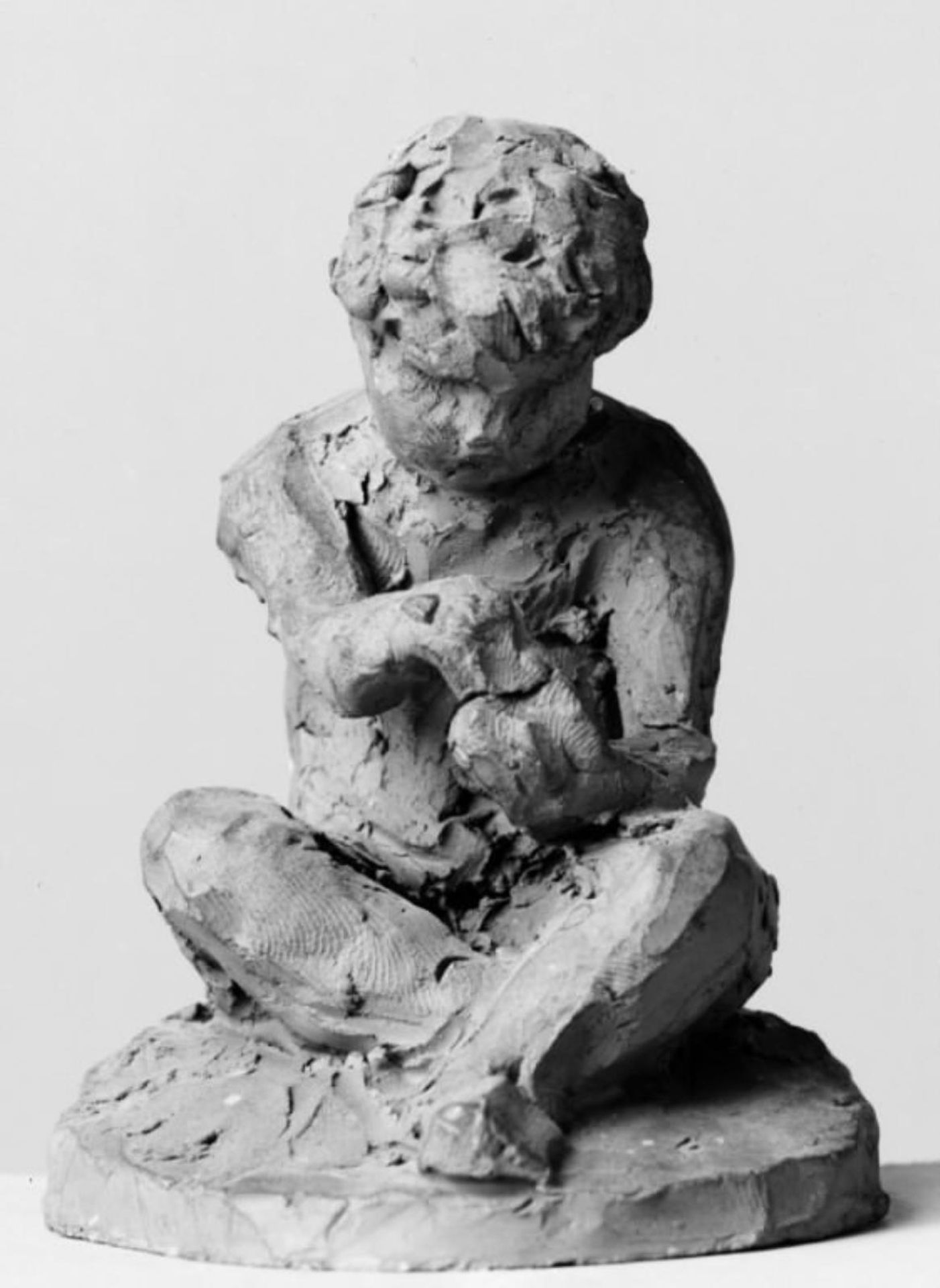 Lille siddende, nøgen dreng by O. Evens