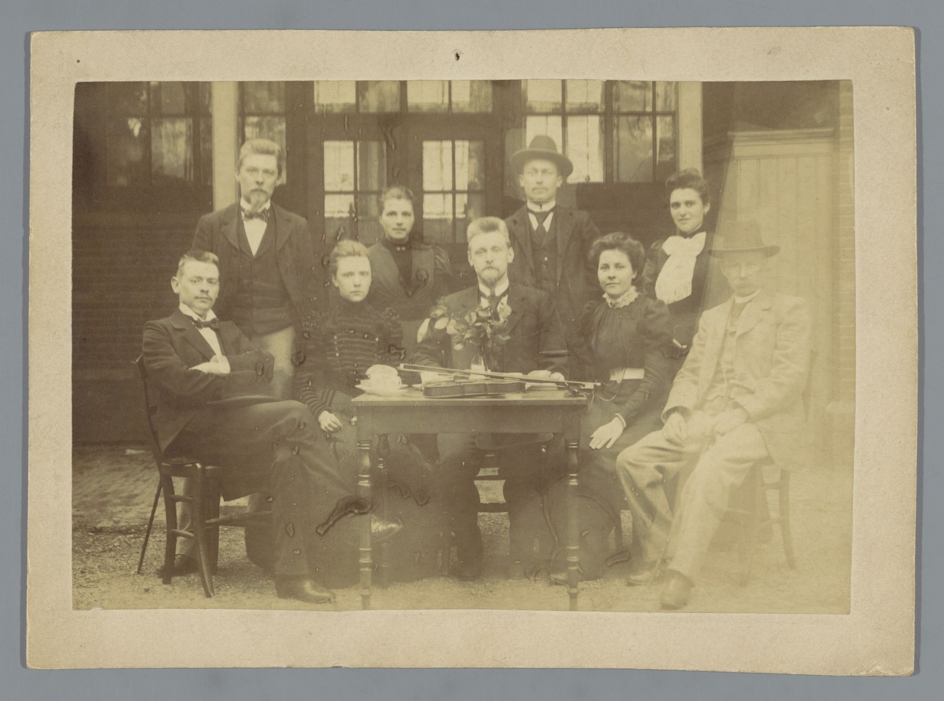 Groepsportret van een onbekende familie rond een tafel met daarop een viool by Hartog Philippus van Adelsbergen