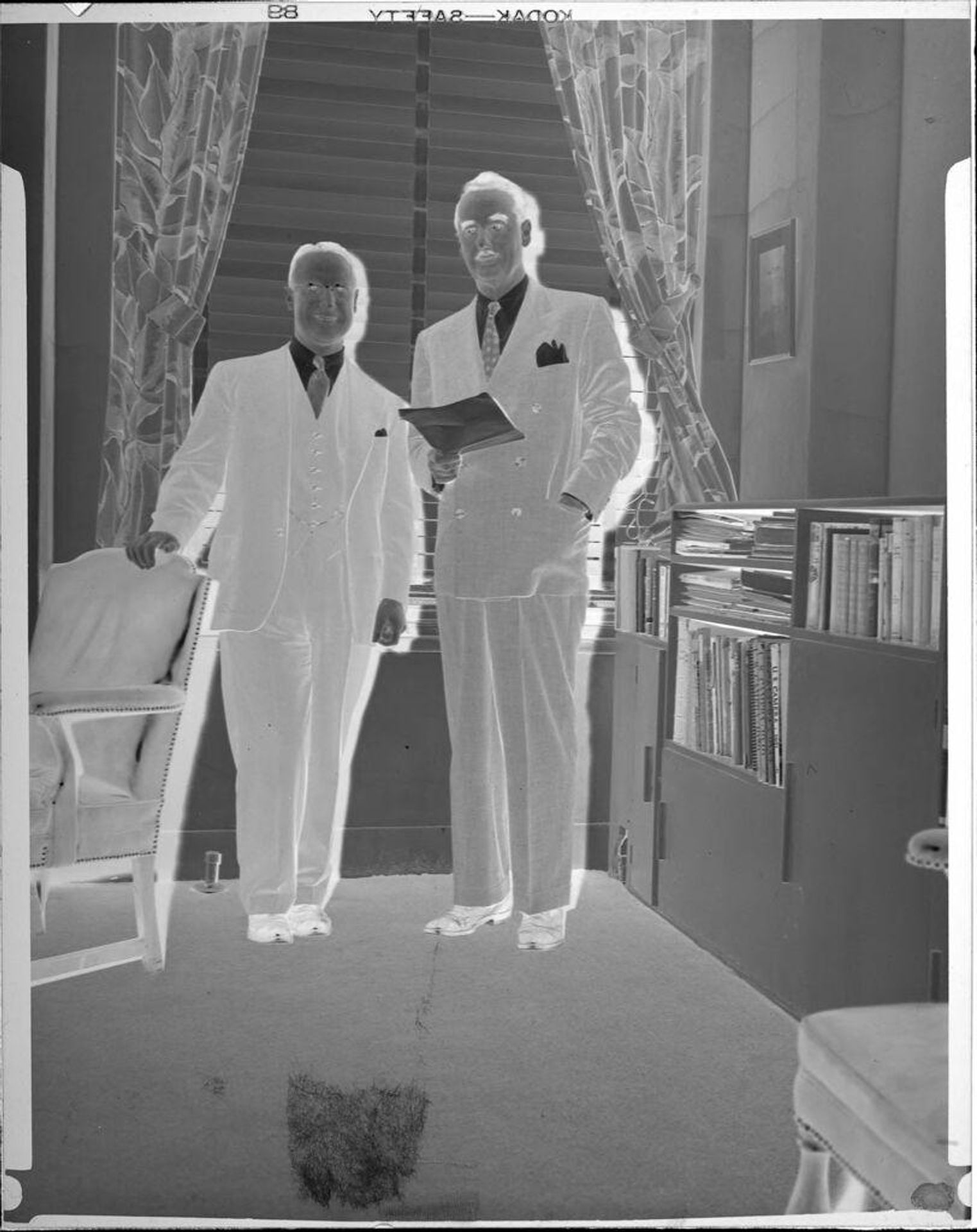 Untitled (two men standing in office) by Peter James Studio