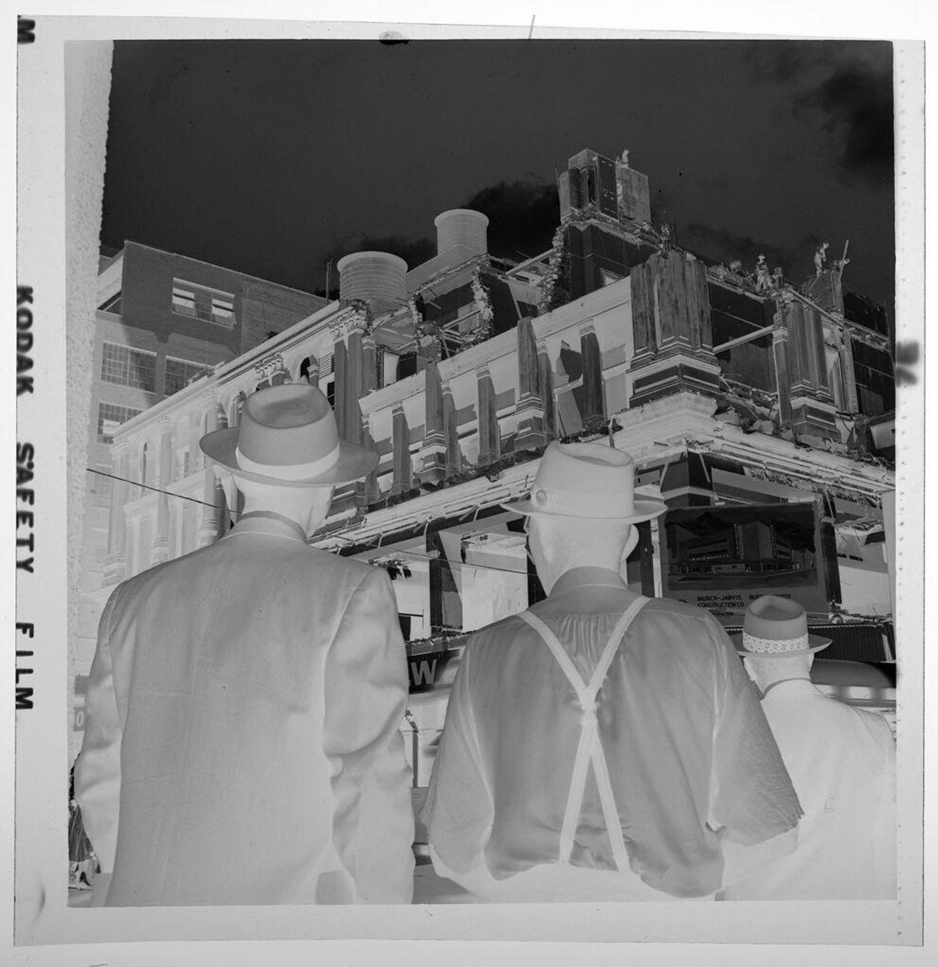 Untitled (two men seen from behind looking at building) by Jack Gould