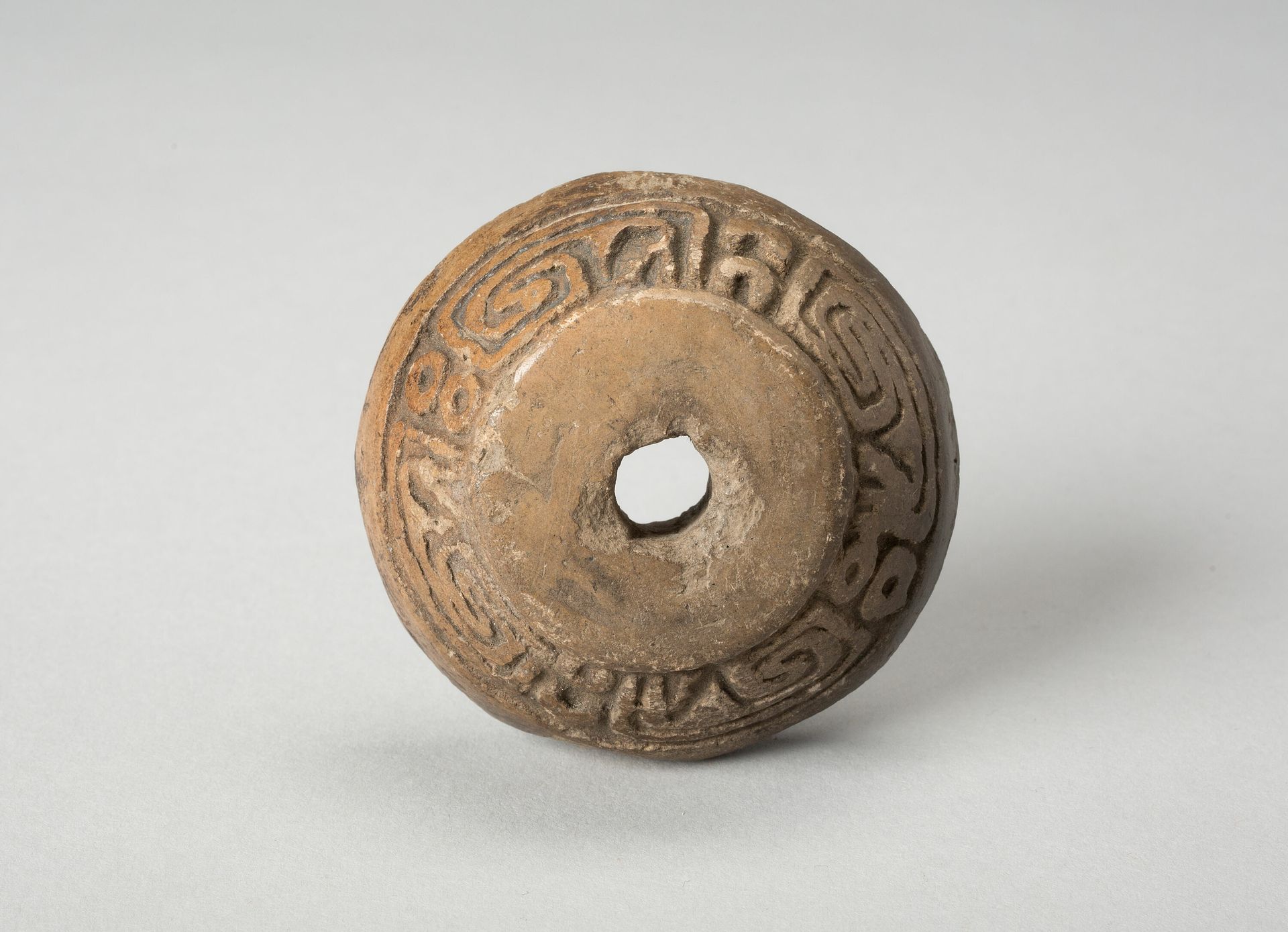 Ear Ornament or Spindle Whorl with Modeled Design by Aztec (Mexica)