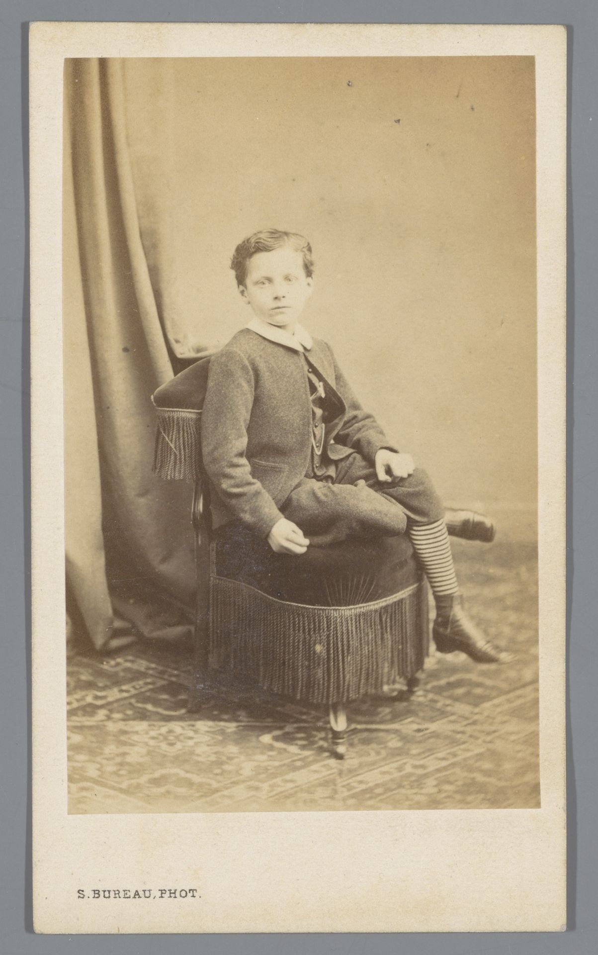 Portret van een onbekende jongen op een stoel by Eugène Vaillat