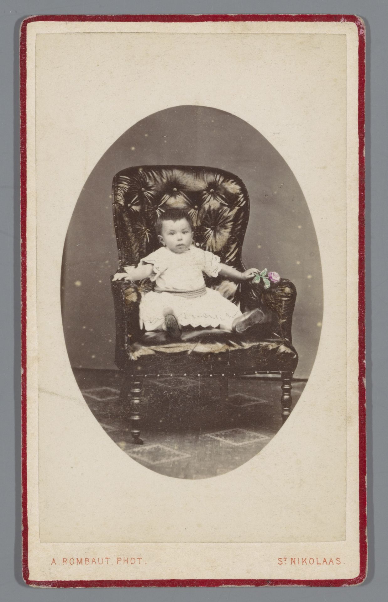 Portret van een onbekend kind met een bloem in een fauteuil by August Rombaut