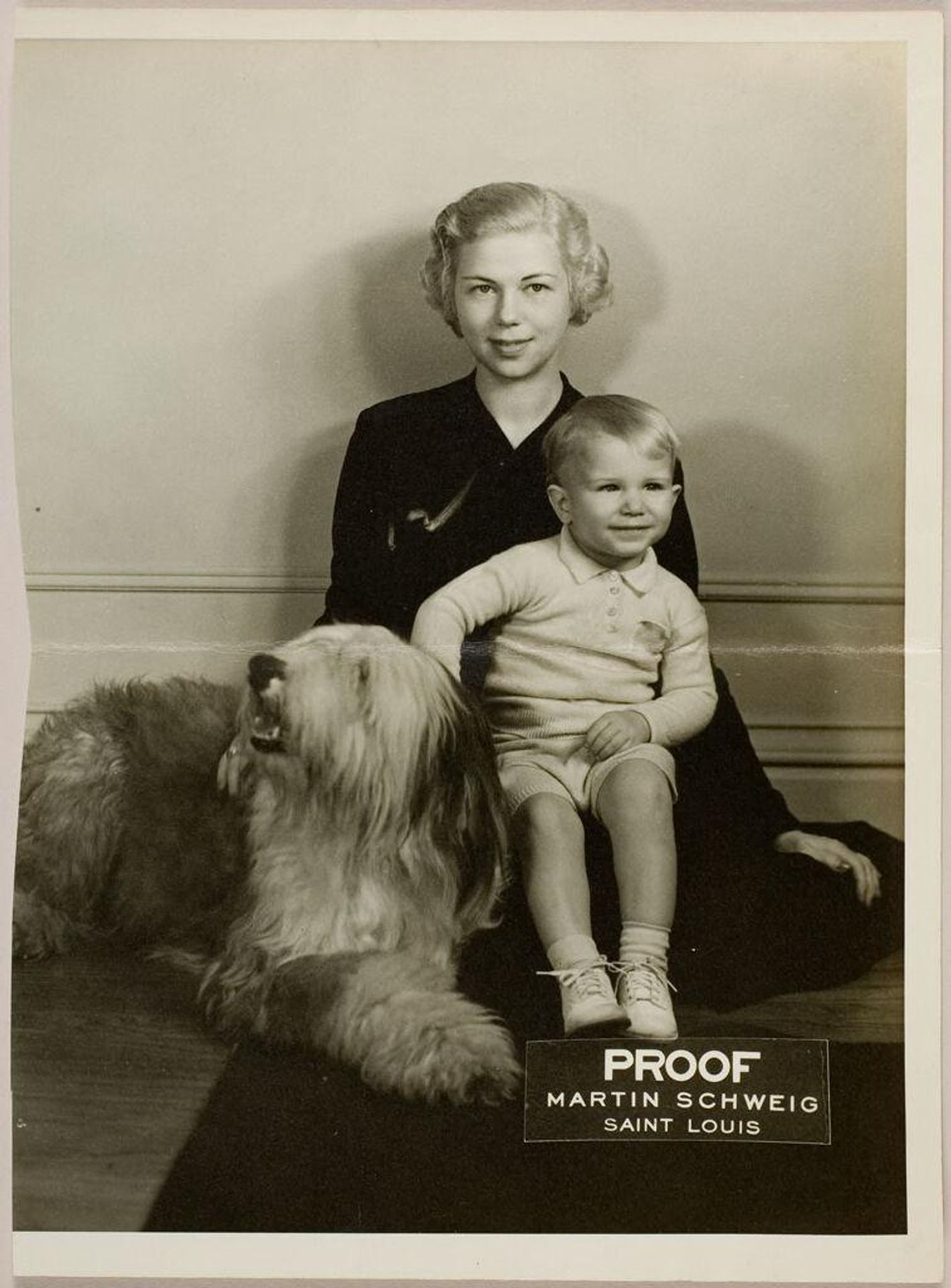 Untitled (young woman posed sitting on floor with dog and young boy) by Martin Schweig