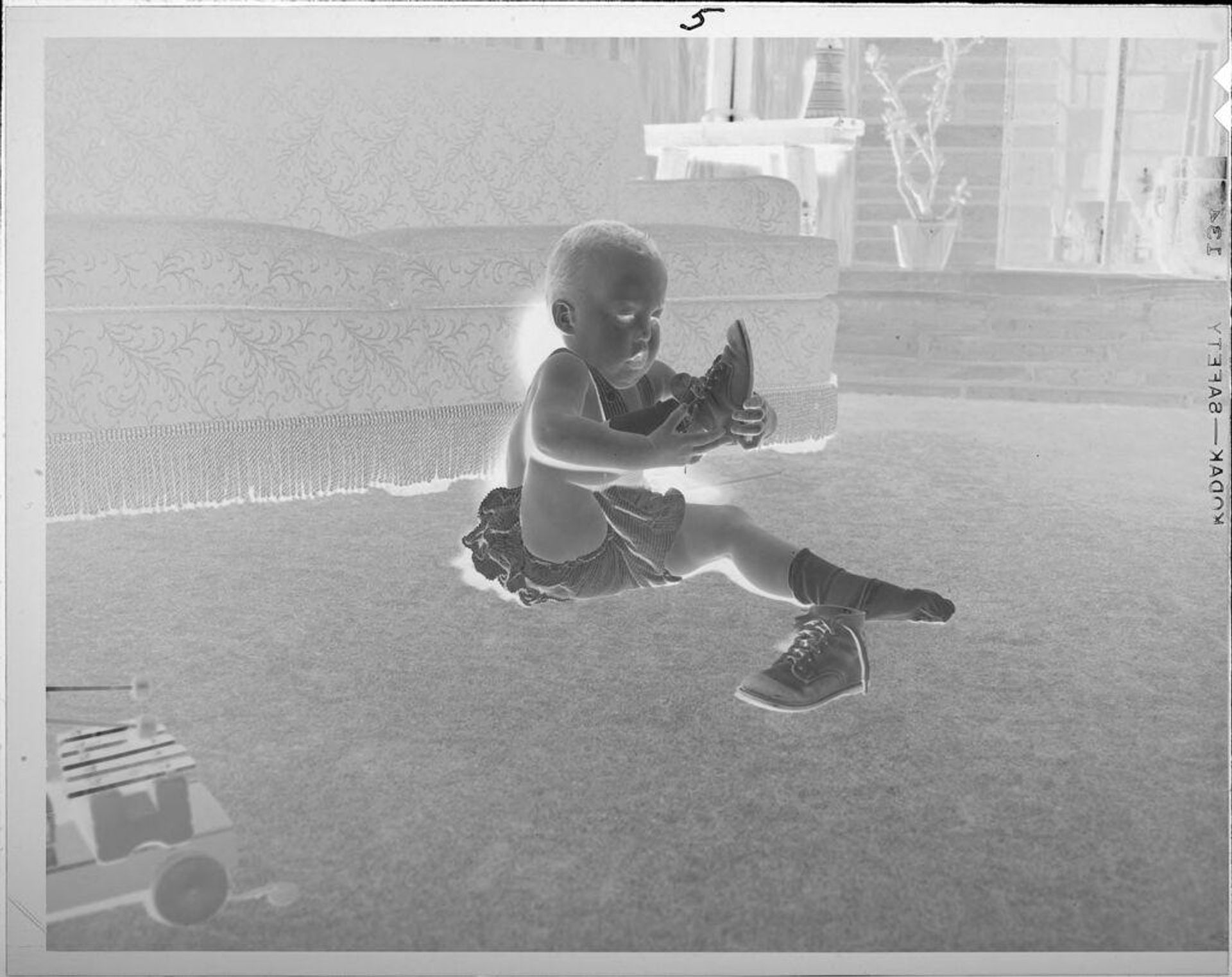 Untitled (baby putting on shoes) by Lucian and Mary Brown