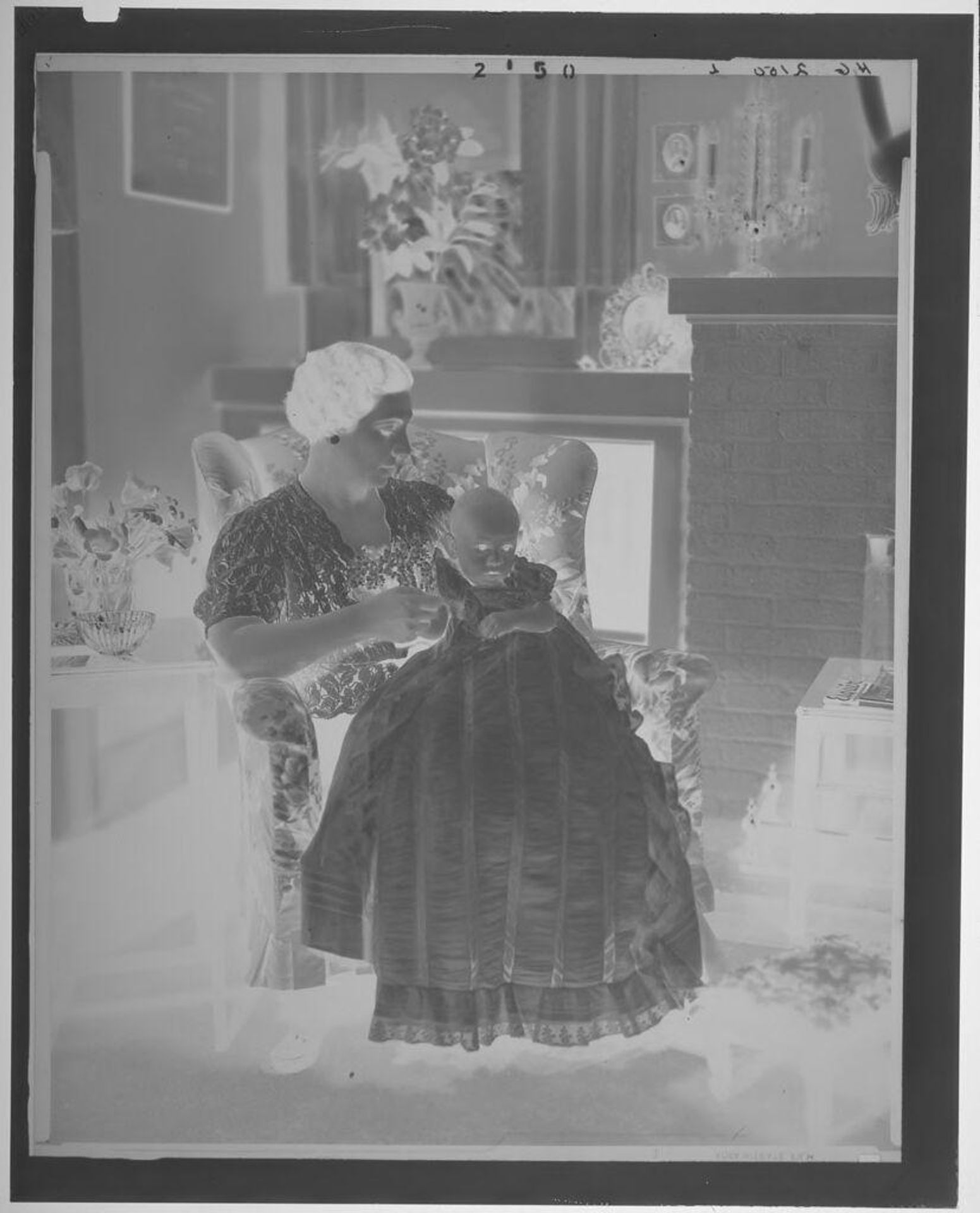 Untitled (woman seated in armchair with baby in long dress on lap) by Paul Gittings