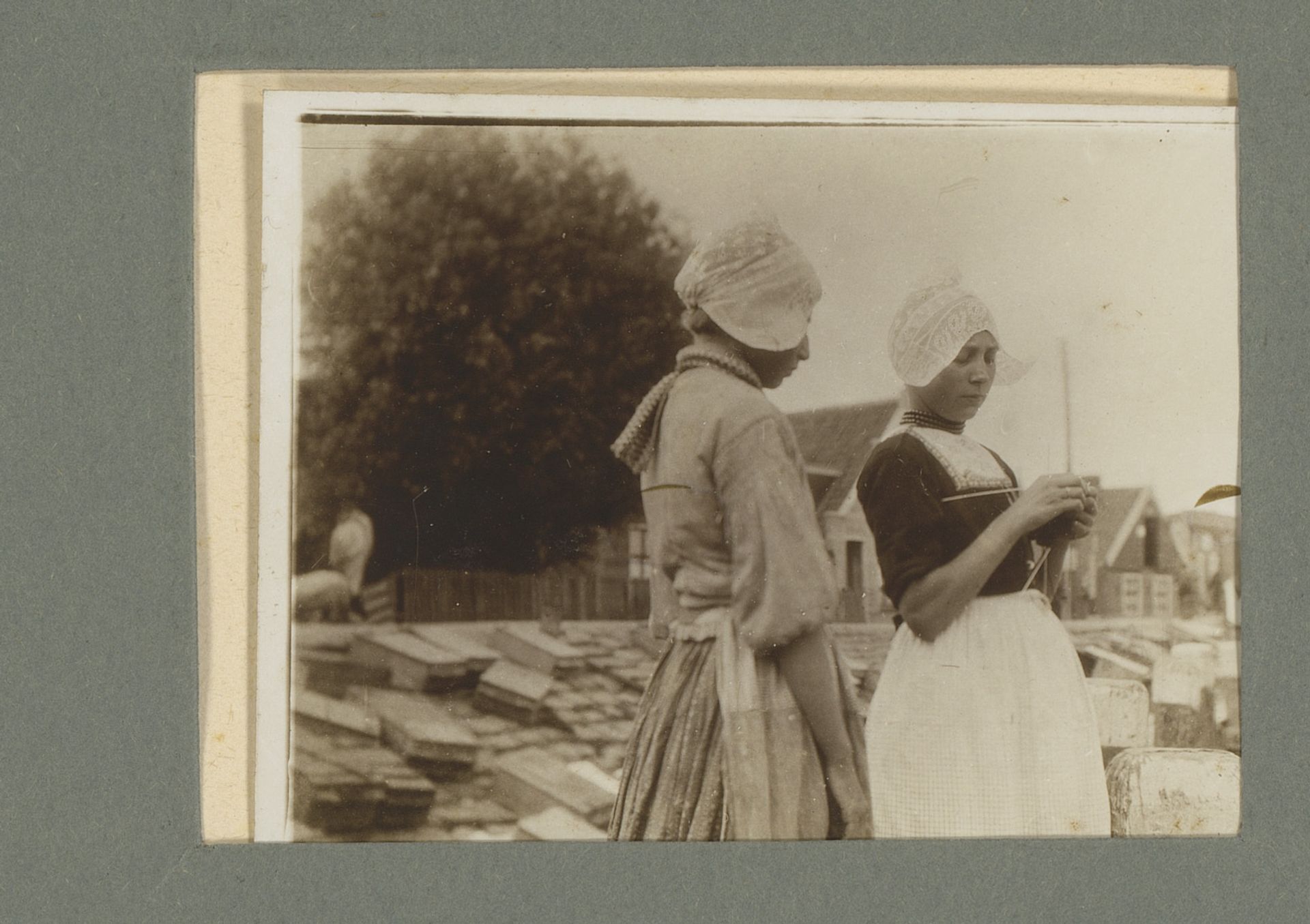 Twee vrouwen met een Volendammer hul by G. Hidderley
