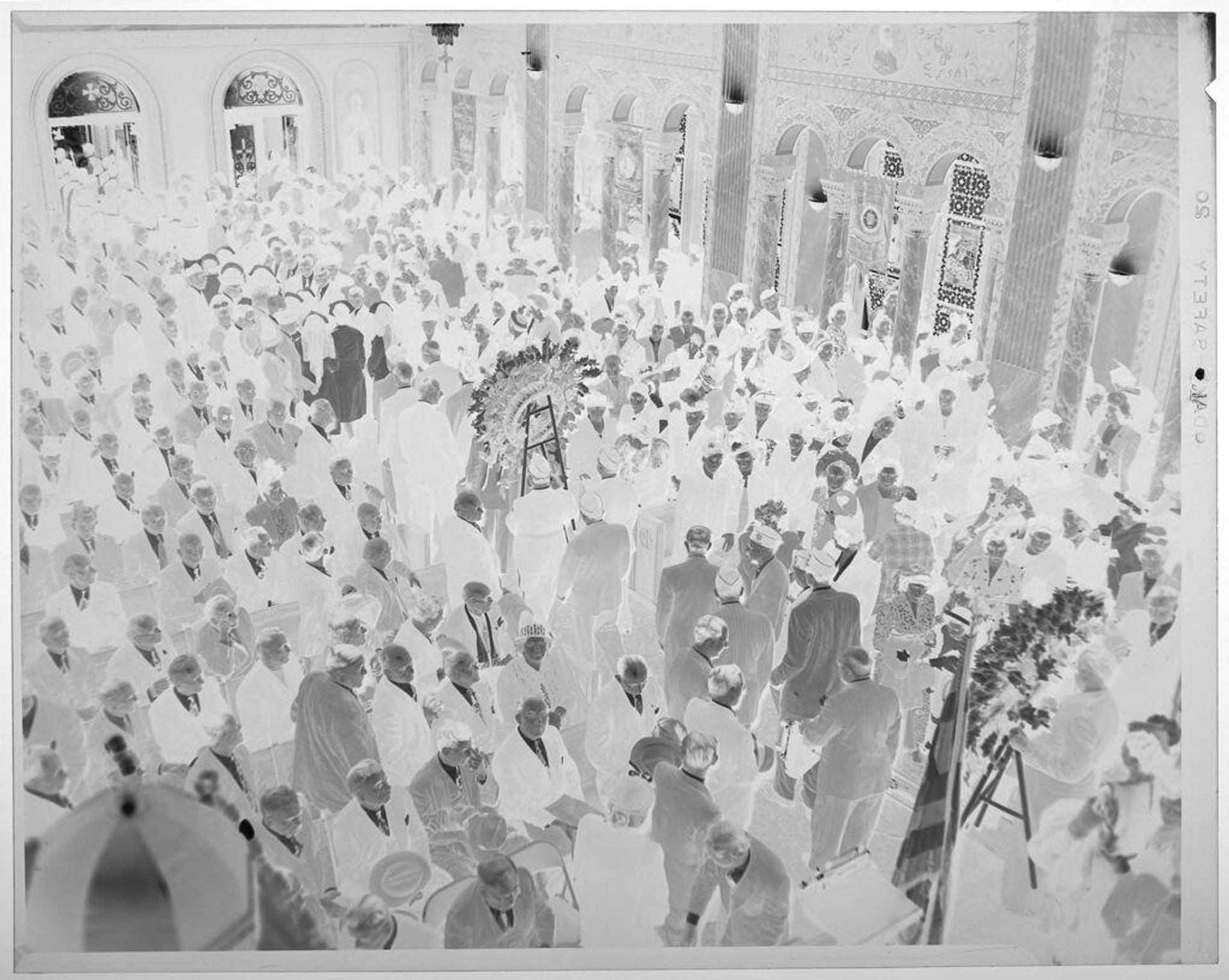 Untitled (elevated view of church interior with people seated in pews and assembly filing through center) by Martin Schweig