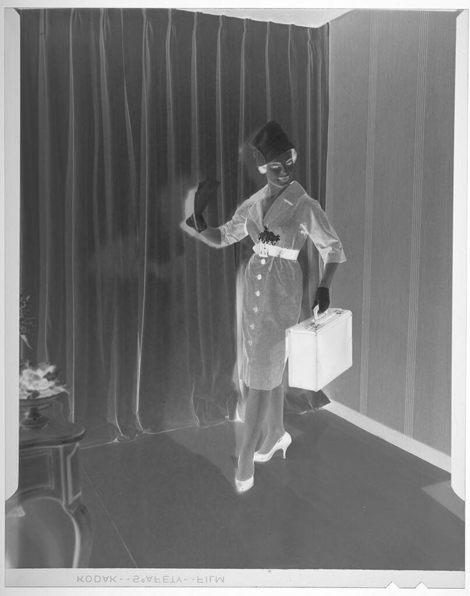 Untitled (fashion portrait of woman in suit holding briefcase in stylized pose) by Martin Schweig