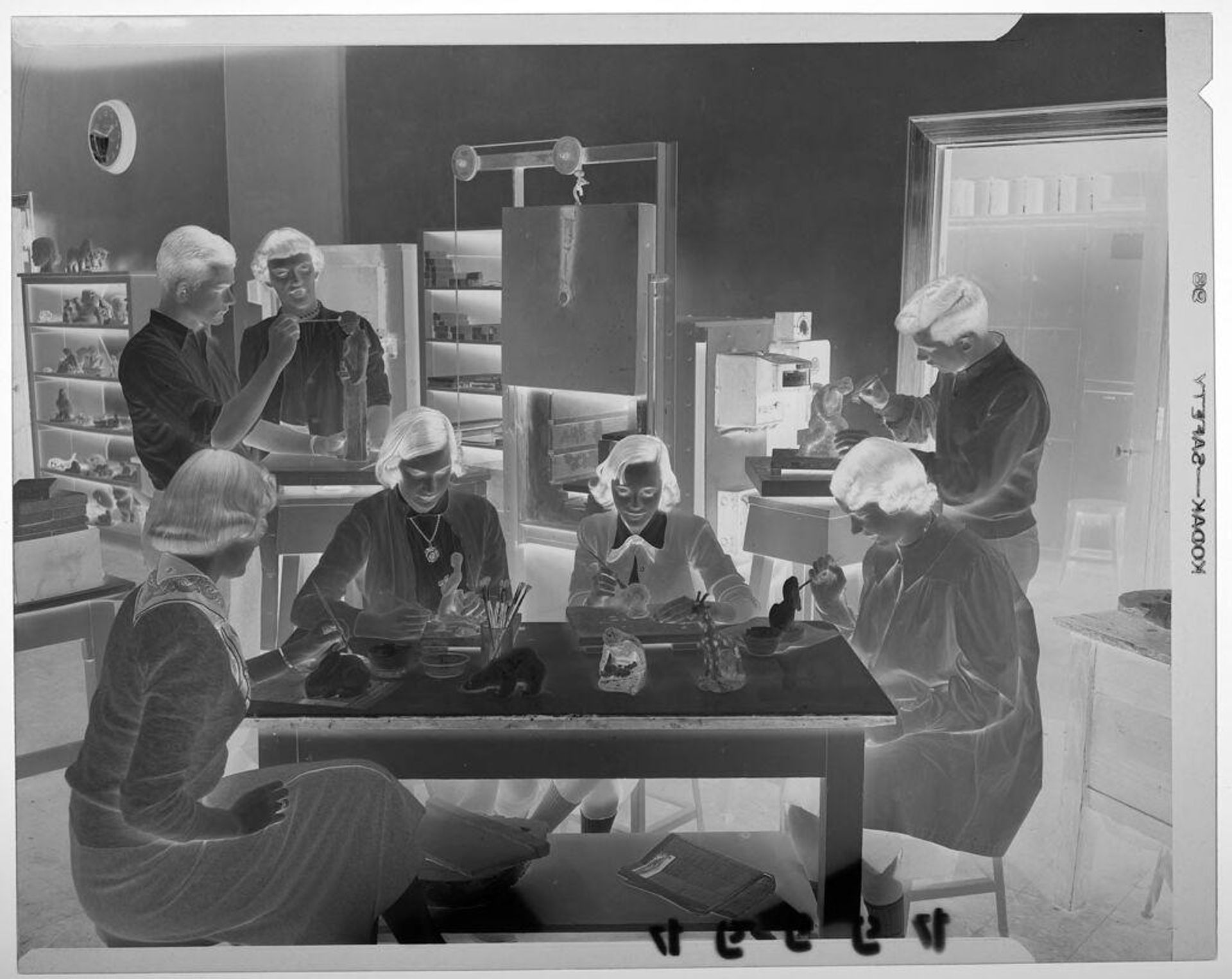 Untitled (seven teenage students painting clay figures in art classroom) by Martin Schweig