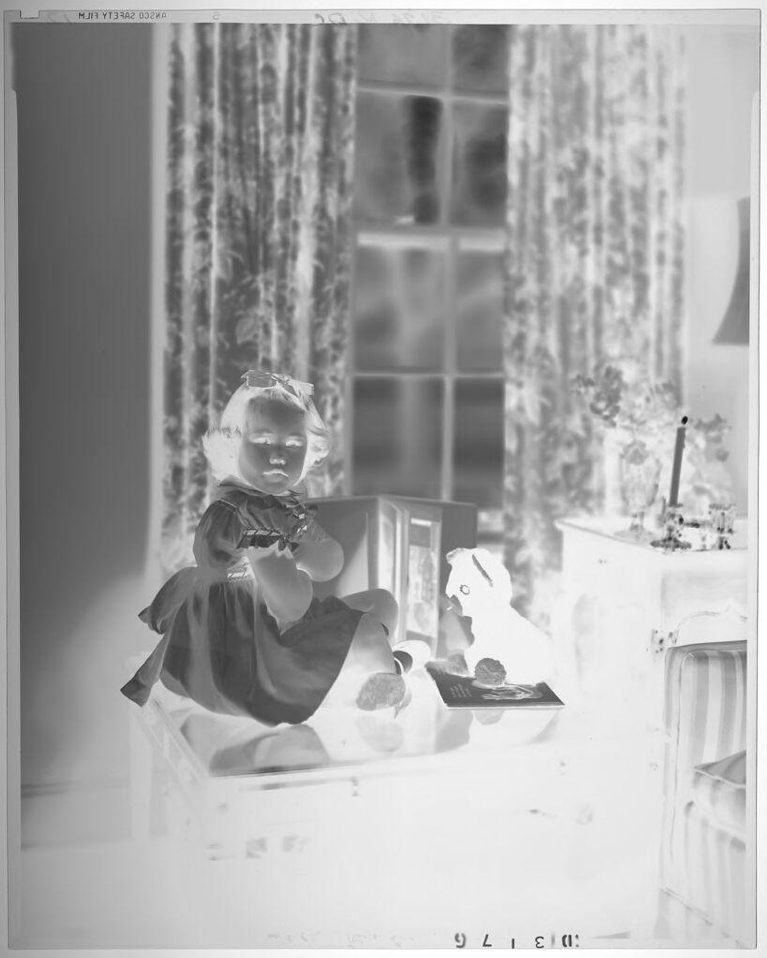 Untitled (girl seated on bench in living room with toys, arms crossed)v by Paul Gittings