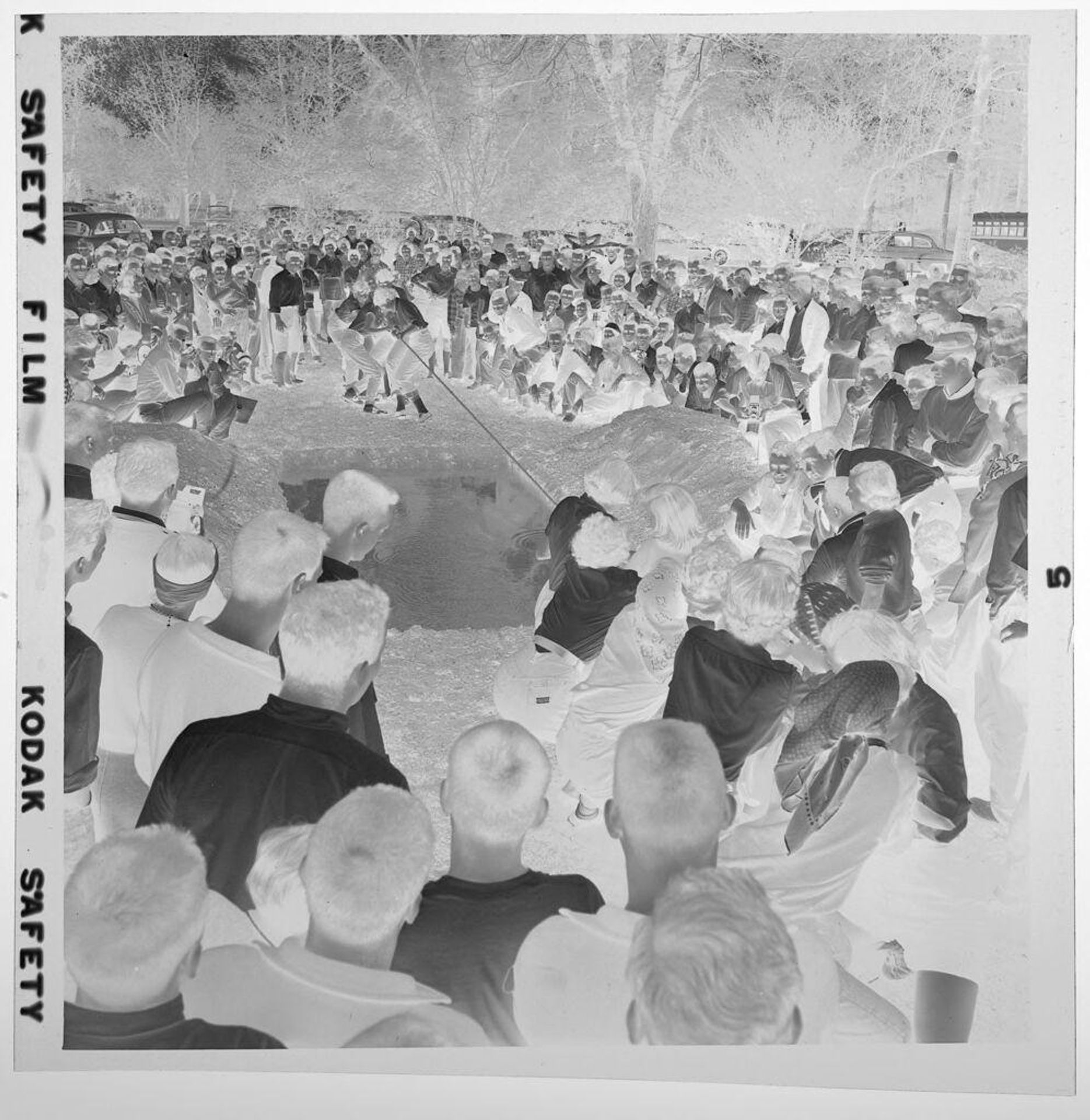 Untitled (large crowd watching tug-of-war over mud pit) by Jack Gould