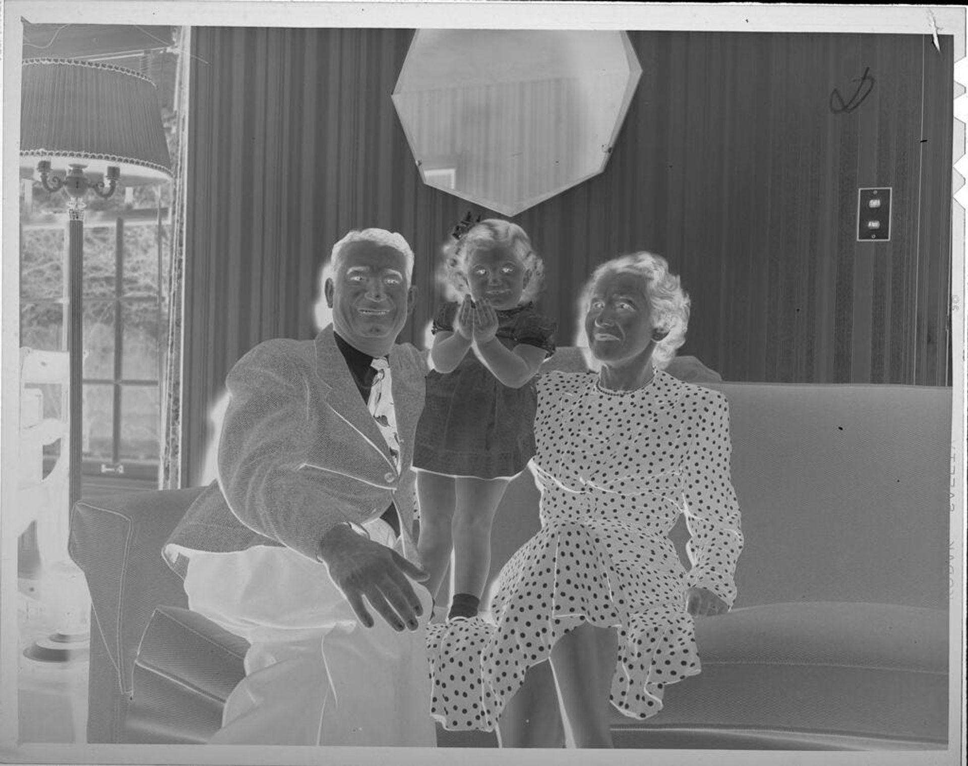 Untitled (man, woman, and girl on couch) by Lucian and Mary Brown