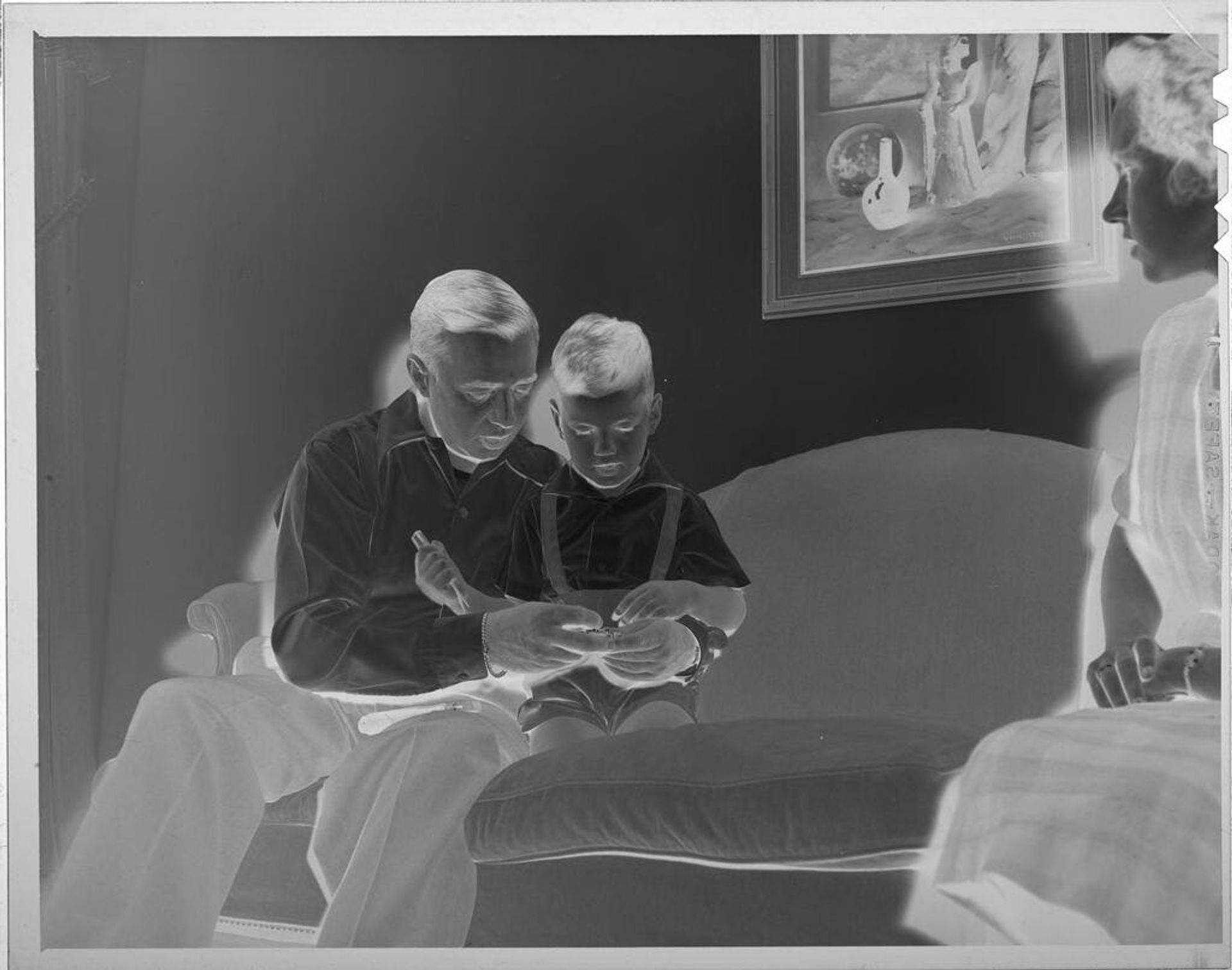 Untitled (man and little boy on couch) by Lucian and Mary Brown