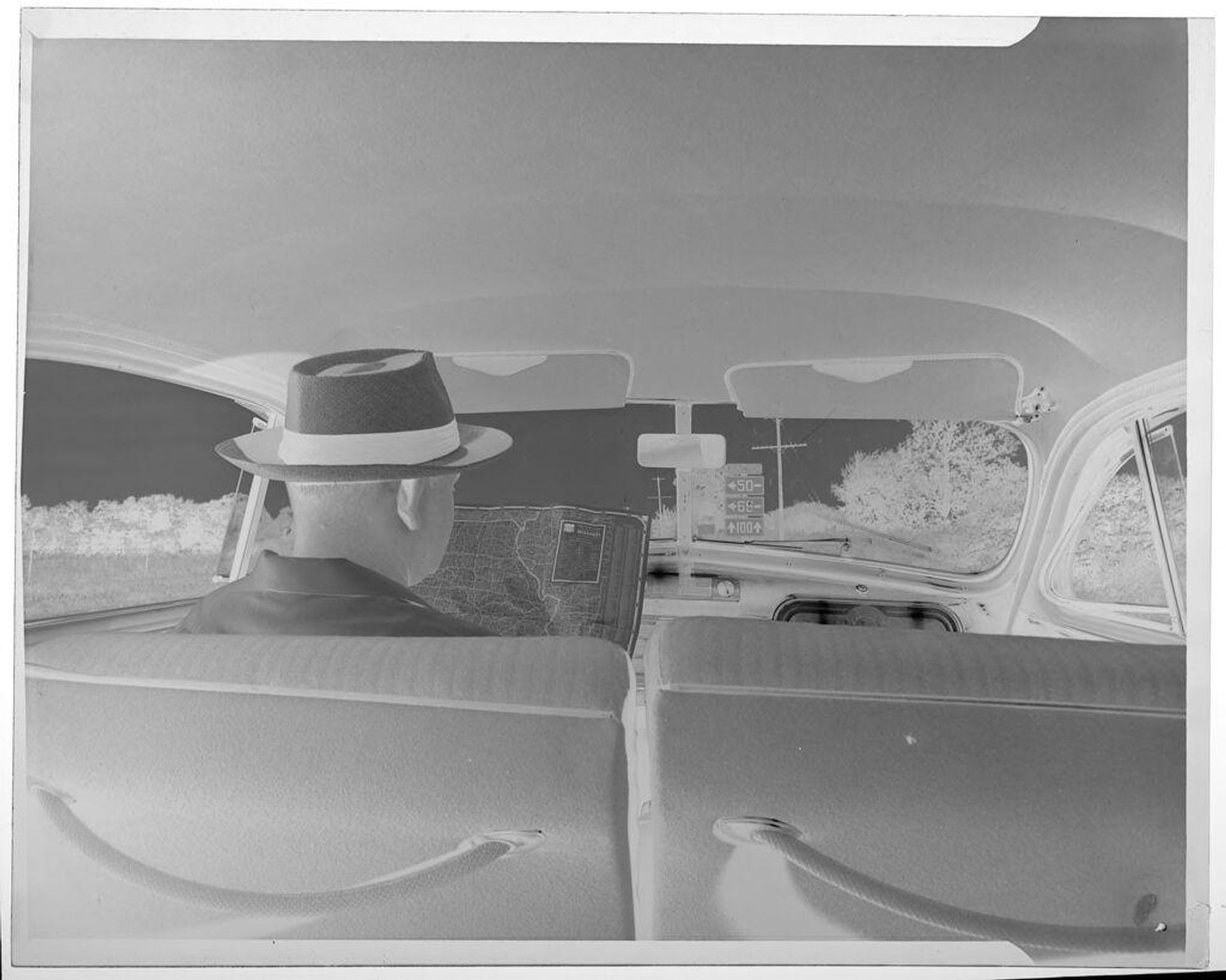 Untitled (man reading map inside car) by Jack Gould