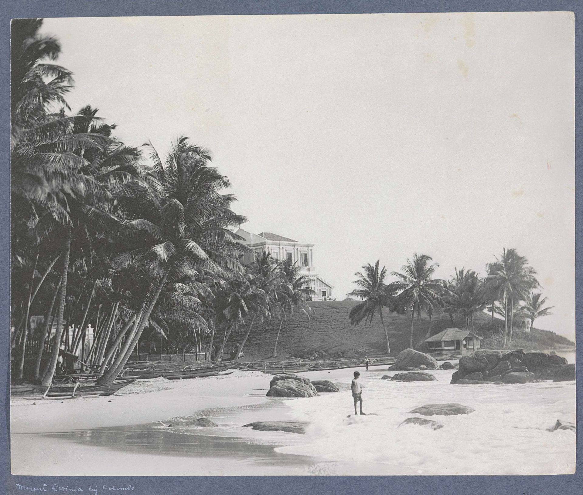 Strand bij Mount Lavinia (Colombo) met palmen, villa en kind in de branding by A.W.A. Plâté & Co.