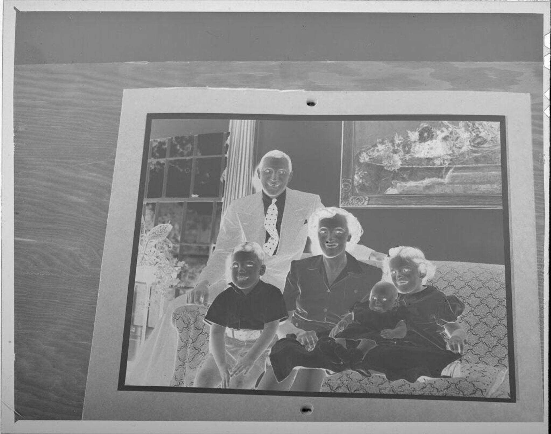 Untitled (photograph of family, mounted on black paper and sitting on table) by Lucian and Mary Brown