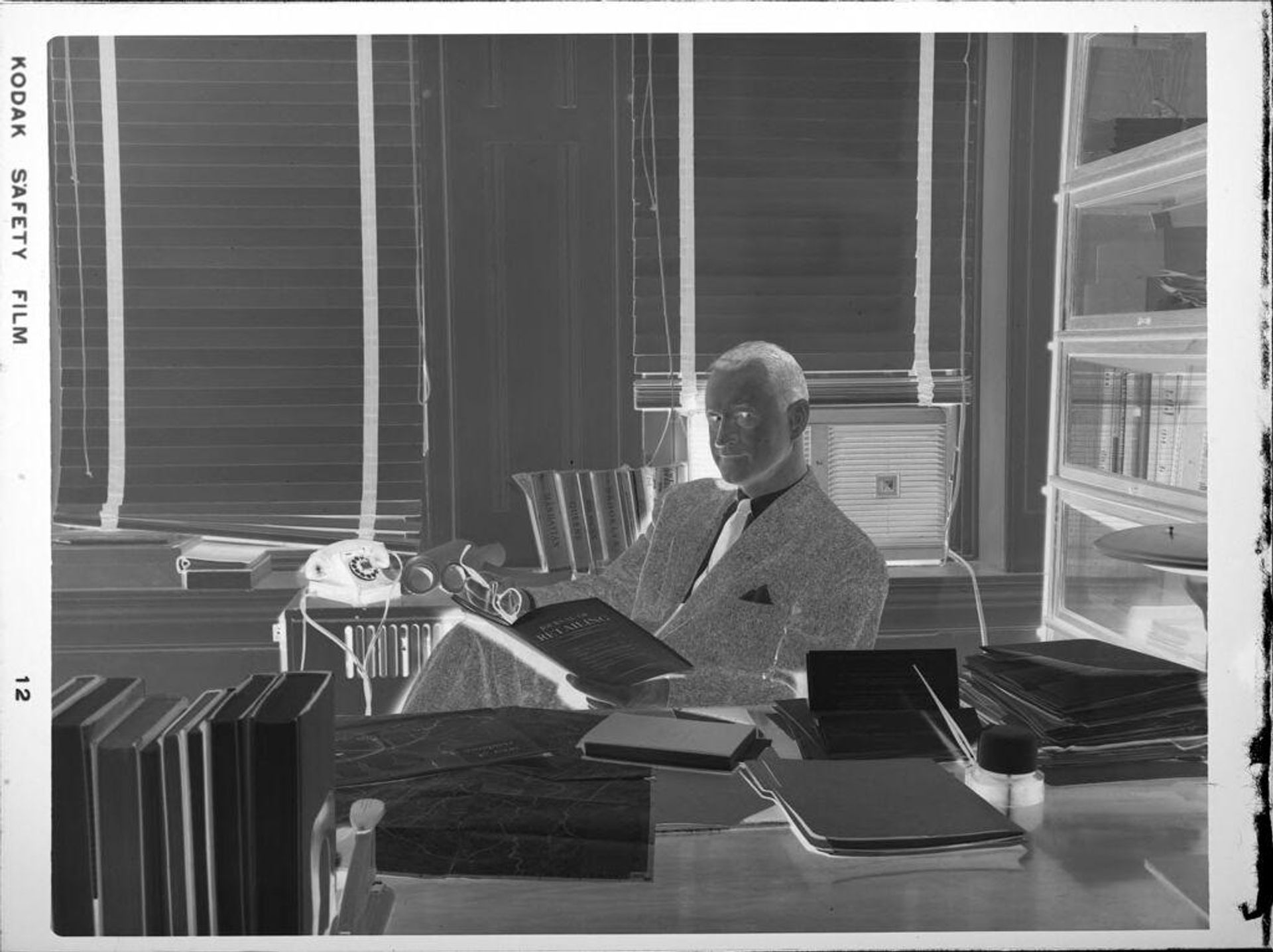 Untitled (man at desk, reading) by Peter James Studio