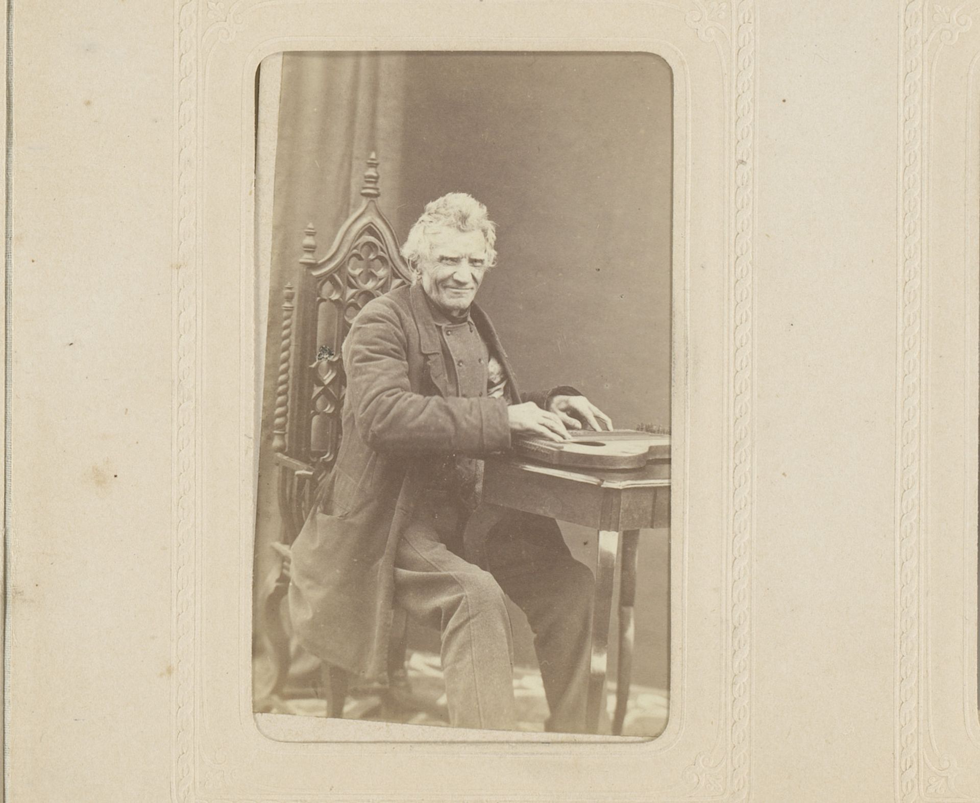Portret van een zittende oude man, spelend op een snaarinstrument by F. Kneifel