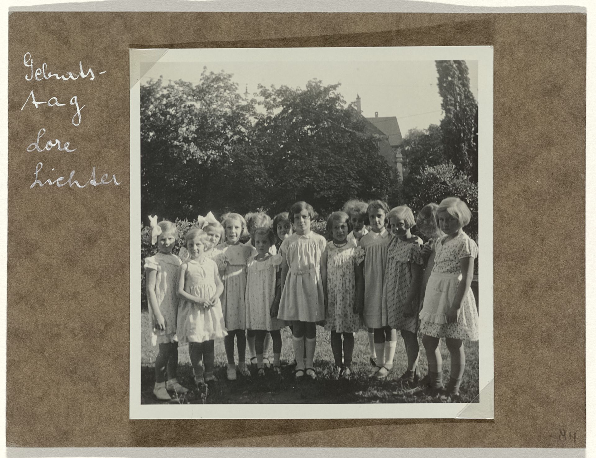 Isabel Wachenheimer met onbekende kinderen op een kinderfeestje in een tuin by Anonymous