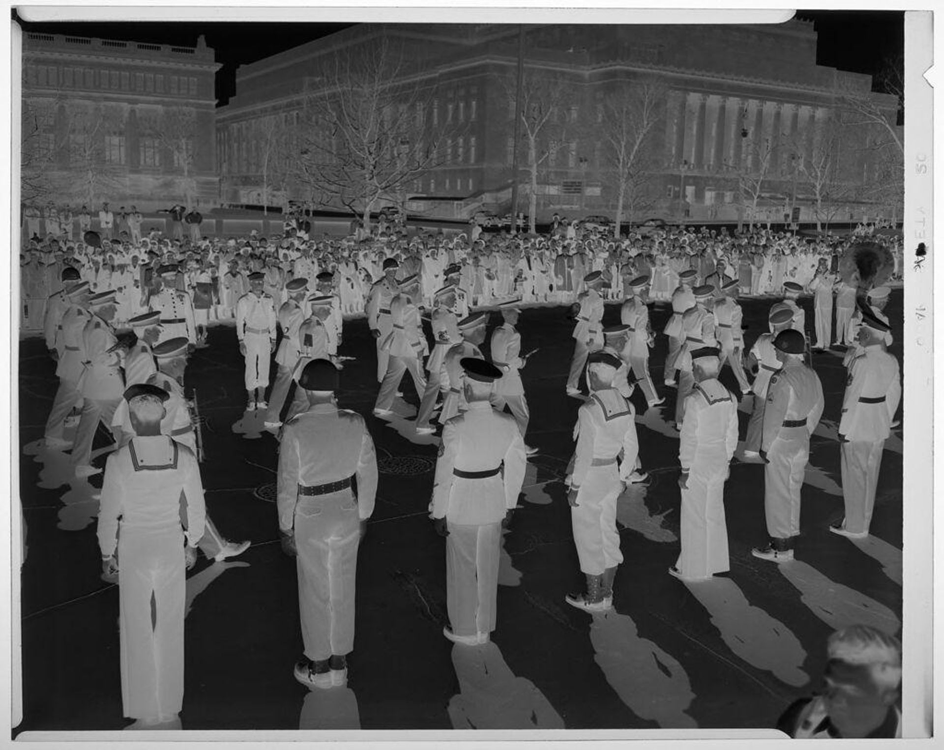 Untitled (view of men in military uniforms making formations in town plaza with audience watching) by Martin Schweig