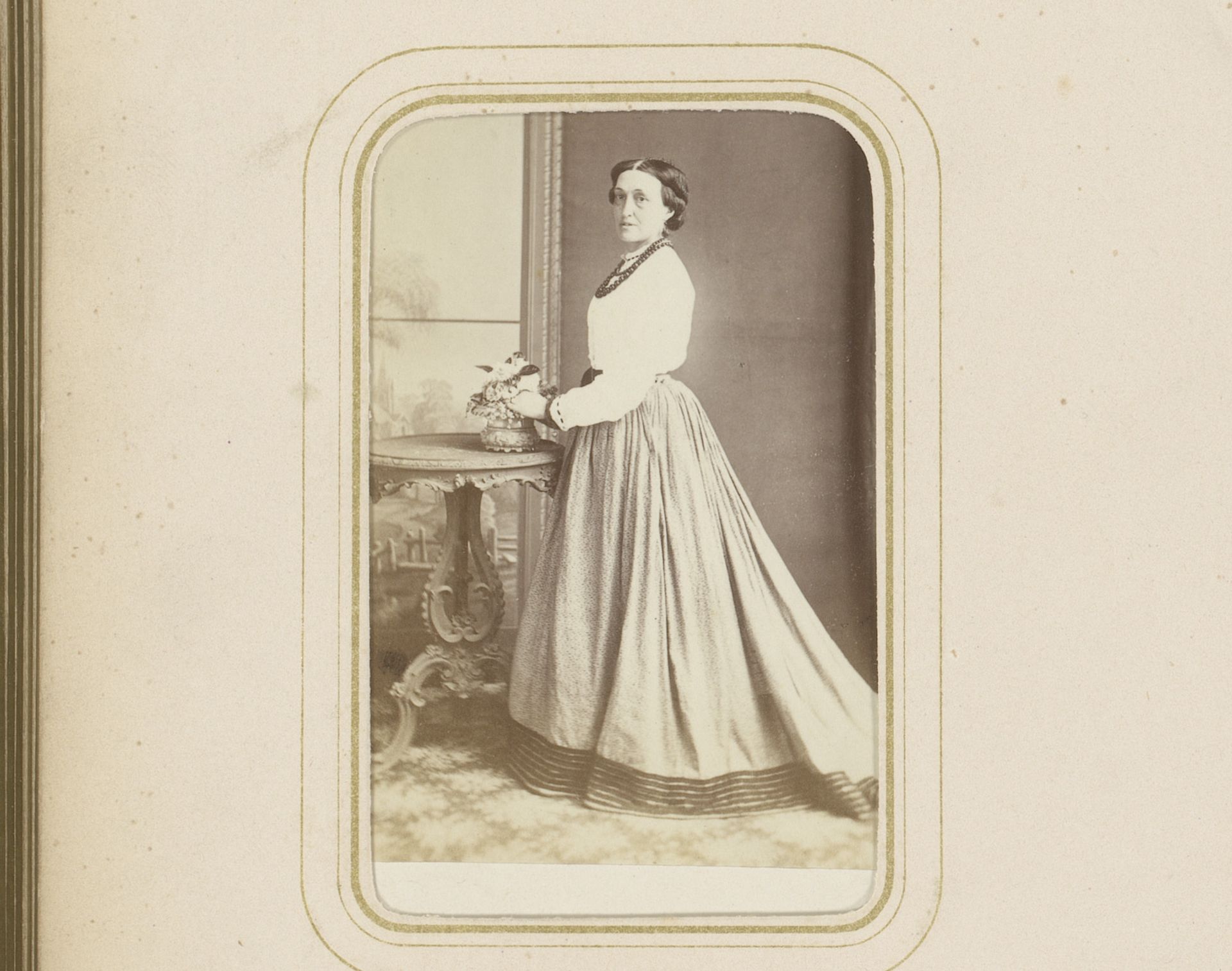 Portret van een vrouw, staand bij een tafel met bloemen by Frances Sutherland Mann