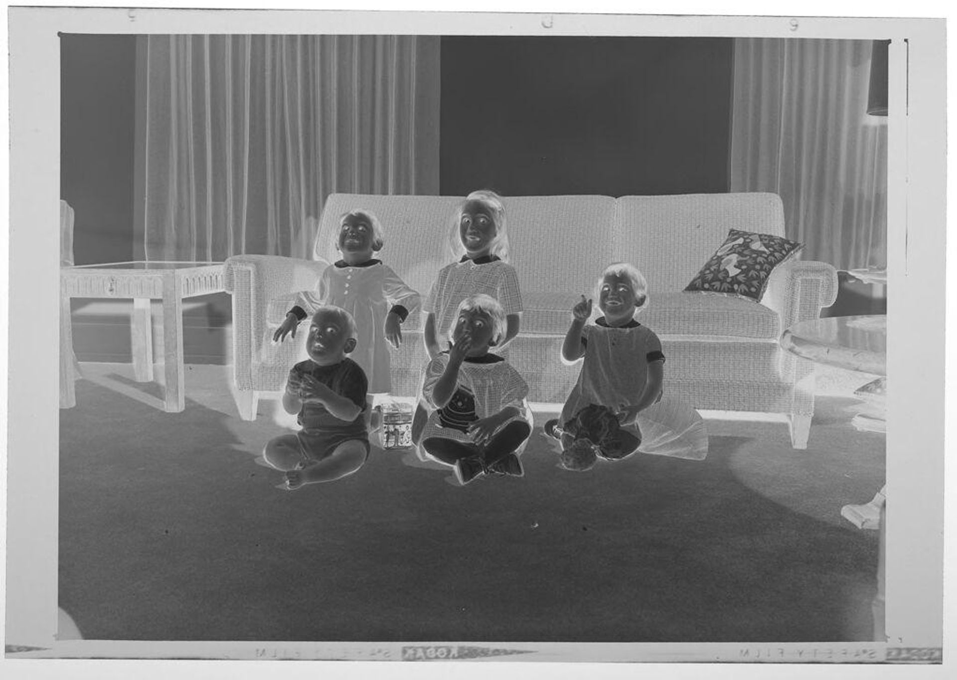 Untitled (five children posed looking upward while sitting on living room floor) by Martin Schweig