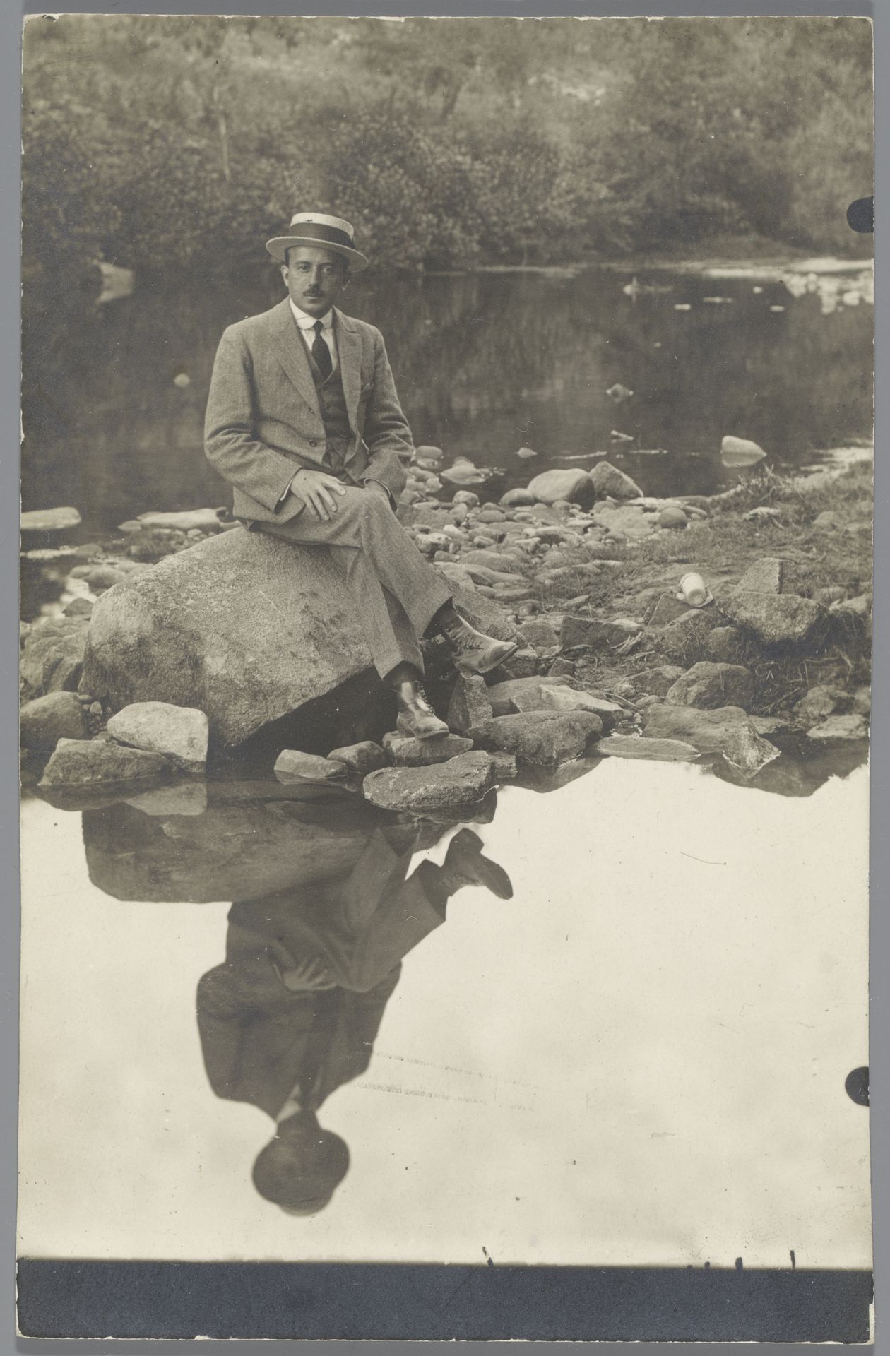 Portret van Benjamin Hernandez zittend op een steen in een rivier, het water reflecteert zijn spiegelbeeld by Arturo Montero