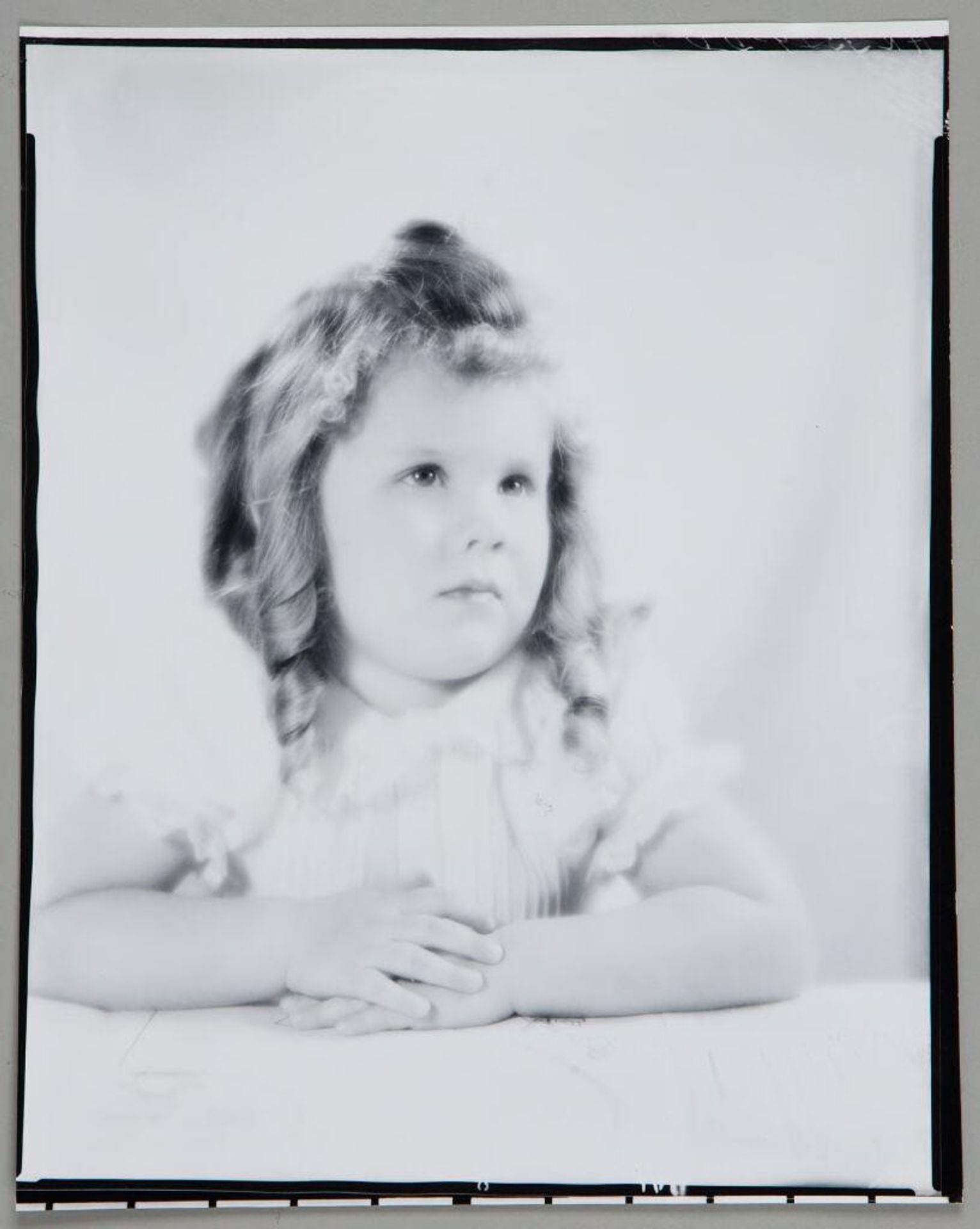 Untitled (portrait of young girl leaning forward on forearms) by Paul Gittings