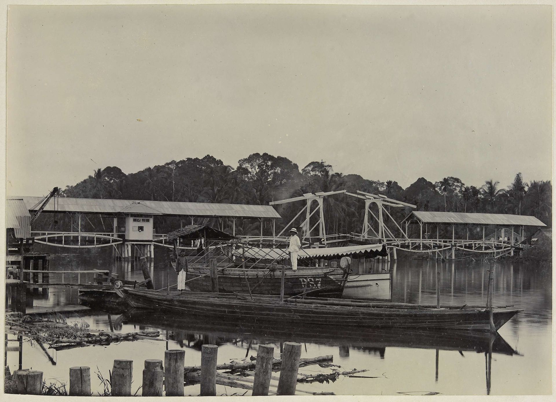 Paul Sandel op boot PS 7 voor de Sandelbrug in de Wampoe rivier, Tandjong Poera,  Langkat Sumatra by Heinrich Ernst & Co