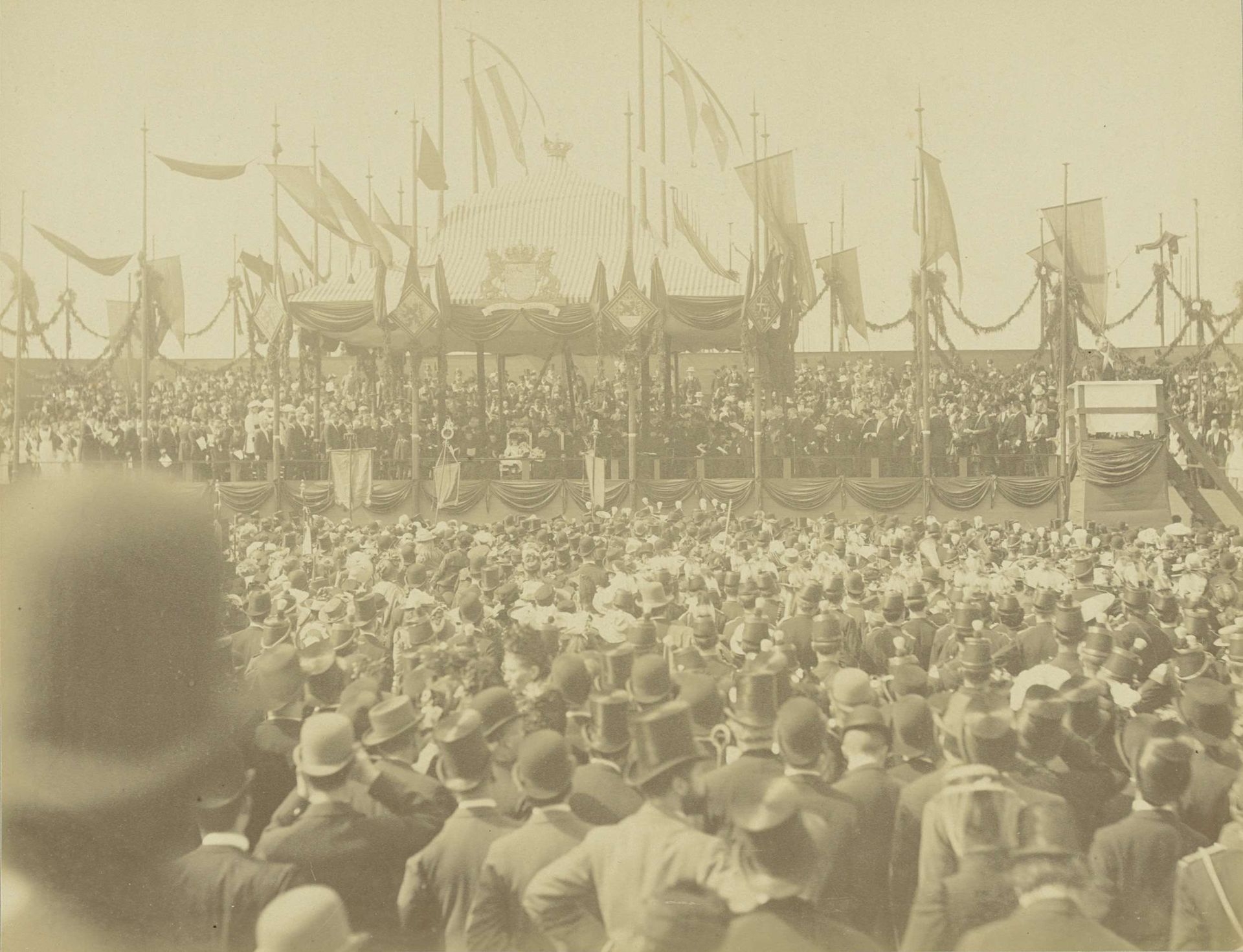Koningin Wilhelmina en regentes Emma tijdens de eerste steenlegging van het Wilhelmina Gasthuis in Amsterdam onder toeziend oog van veel publiek. by Gustaaf Oosterhuis