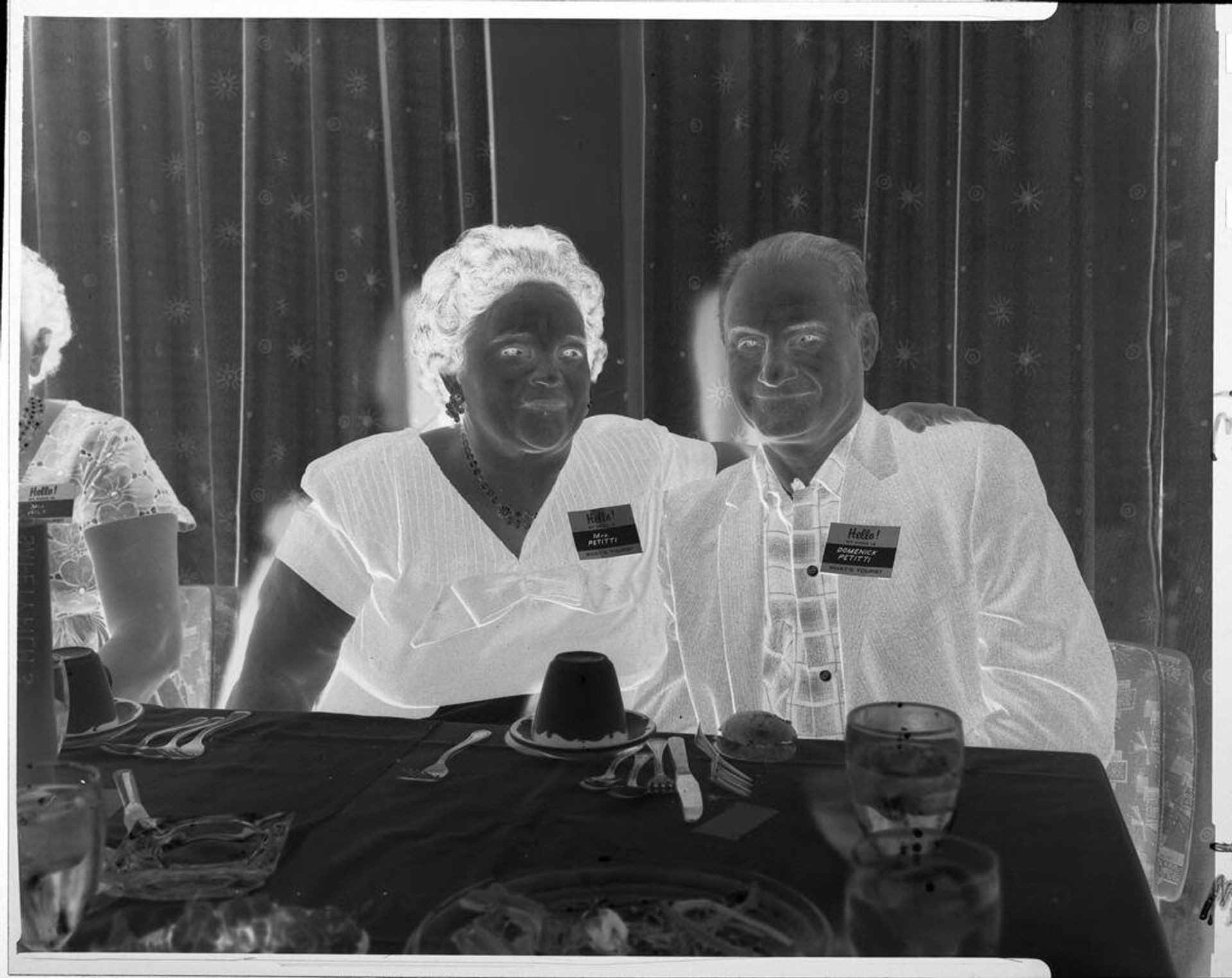Untitled (man and woman at table wearing nametags) by John Howell