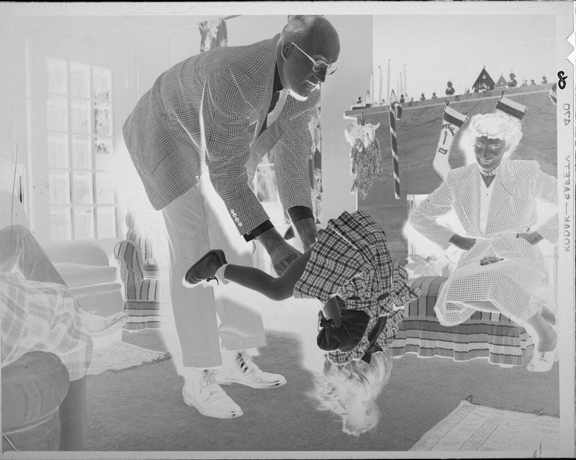 Untitled (man and little girl playing in front of fireplace) by Lucian and Mary Brown