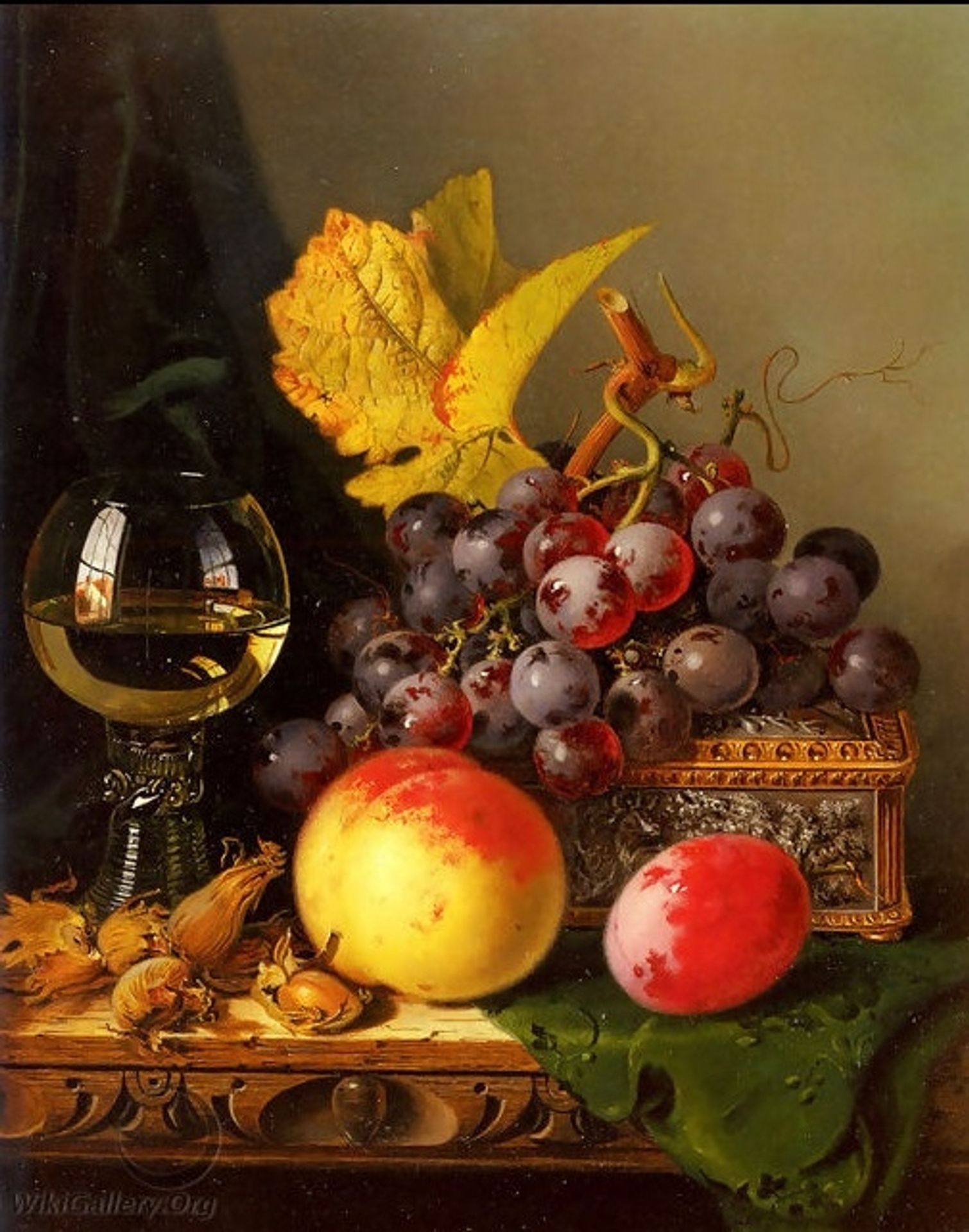A Still Life of Black Grapes, a Peach, a Plum, Hazelnuts, a Metal Casket and a Wine Glass on a Carved Wooden Ledge by Edward Ladell