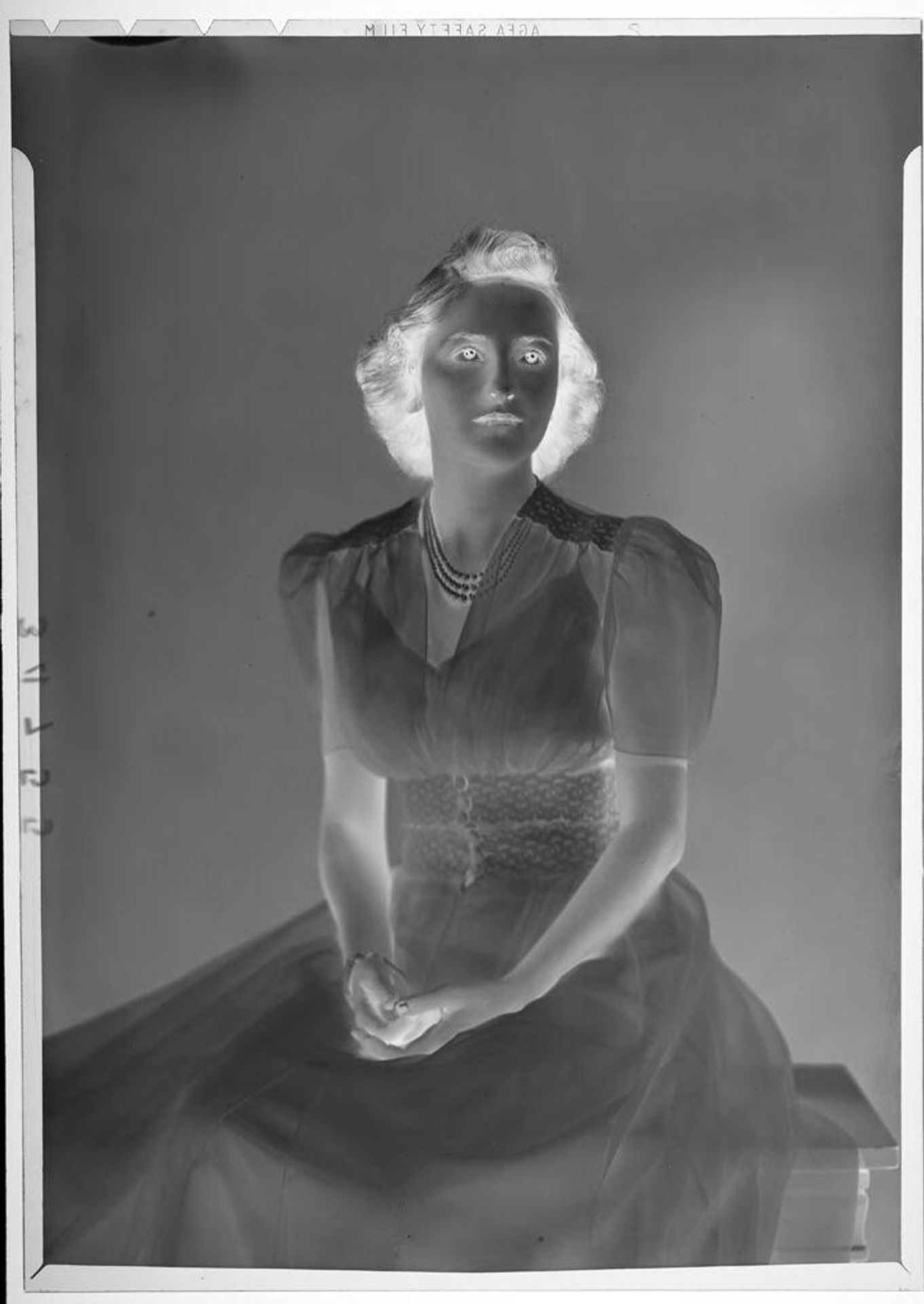 Untitled (studio portrait of woman wearing dress and pearls) by Martin Schweig