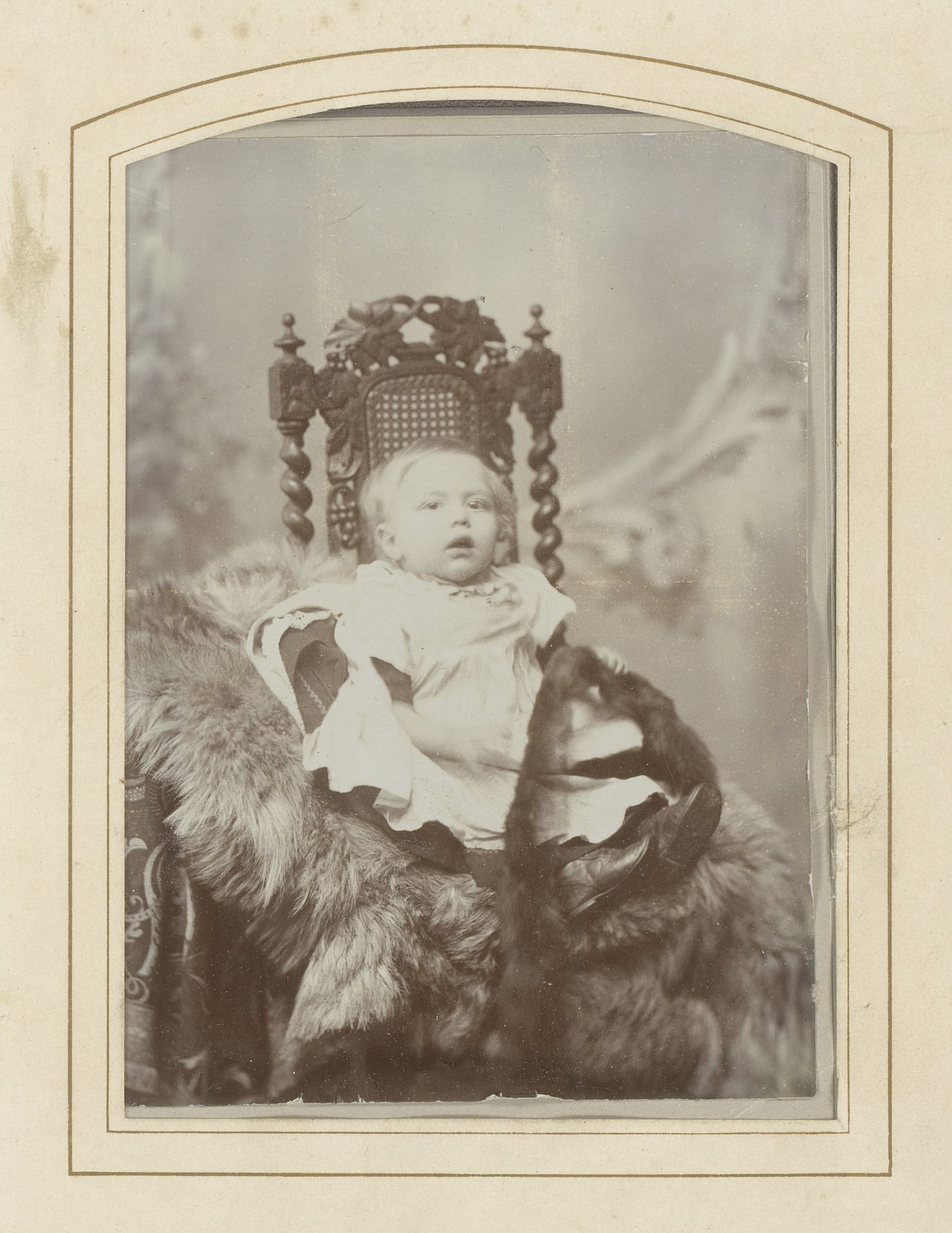 Portret van een baby in een witte jurk met bont in de hand, zittend op een stoel by Bobs