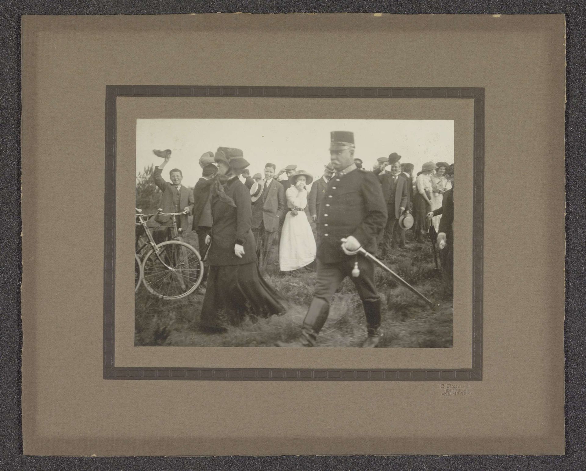 Koningin Wilhelmina loopt door een veld onder begeleiding van de veldwacht. by Coenradus Hendrikus Johannes Reijers
